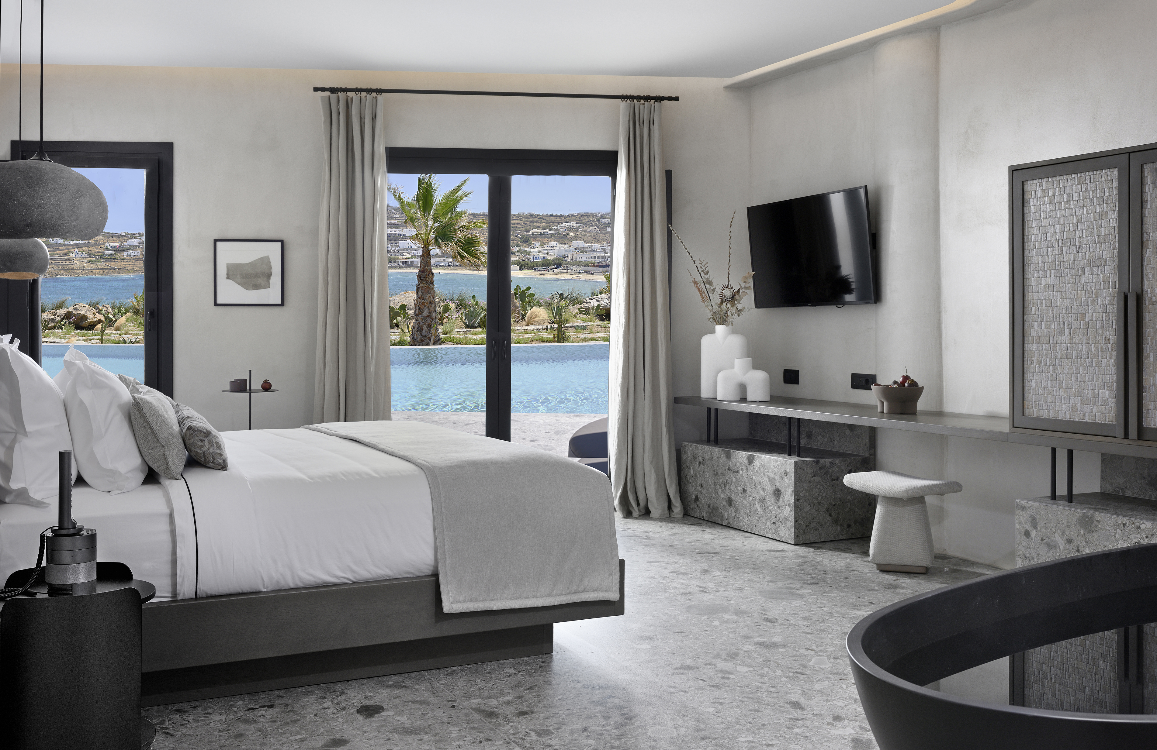 Suite bedroom with desk and sliding doors to private pool at Aeonic Suites & Spa