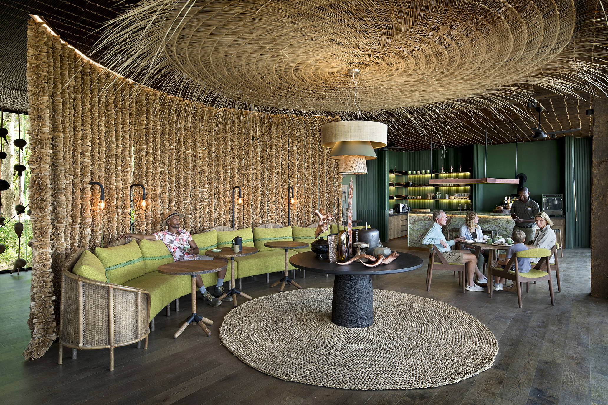 A seating area at Lolebezi filled with people sat around a circular coffee table and large circular ceiling feature