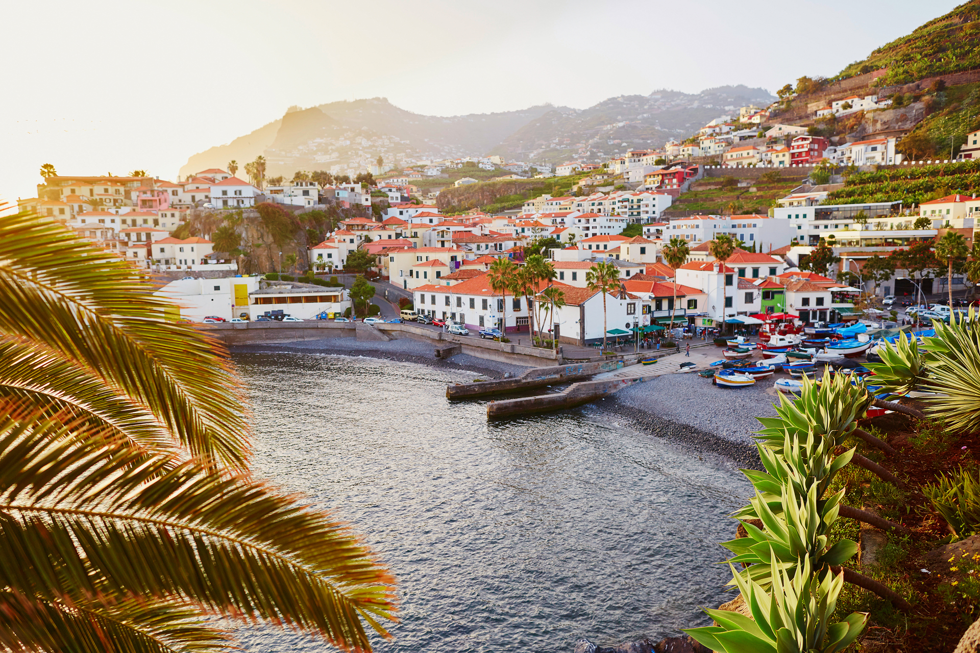 View of the coastal Camara de Lobos village with its white buildings and grassy hills