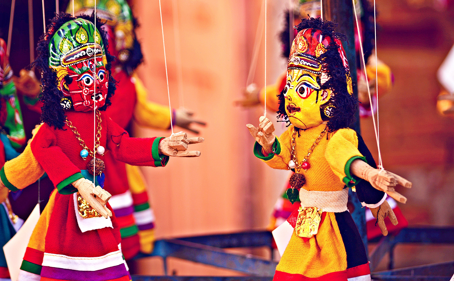 A close up of two colourful deity marionettes