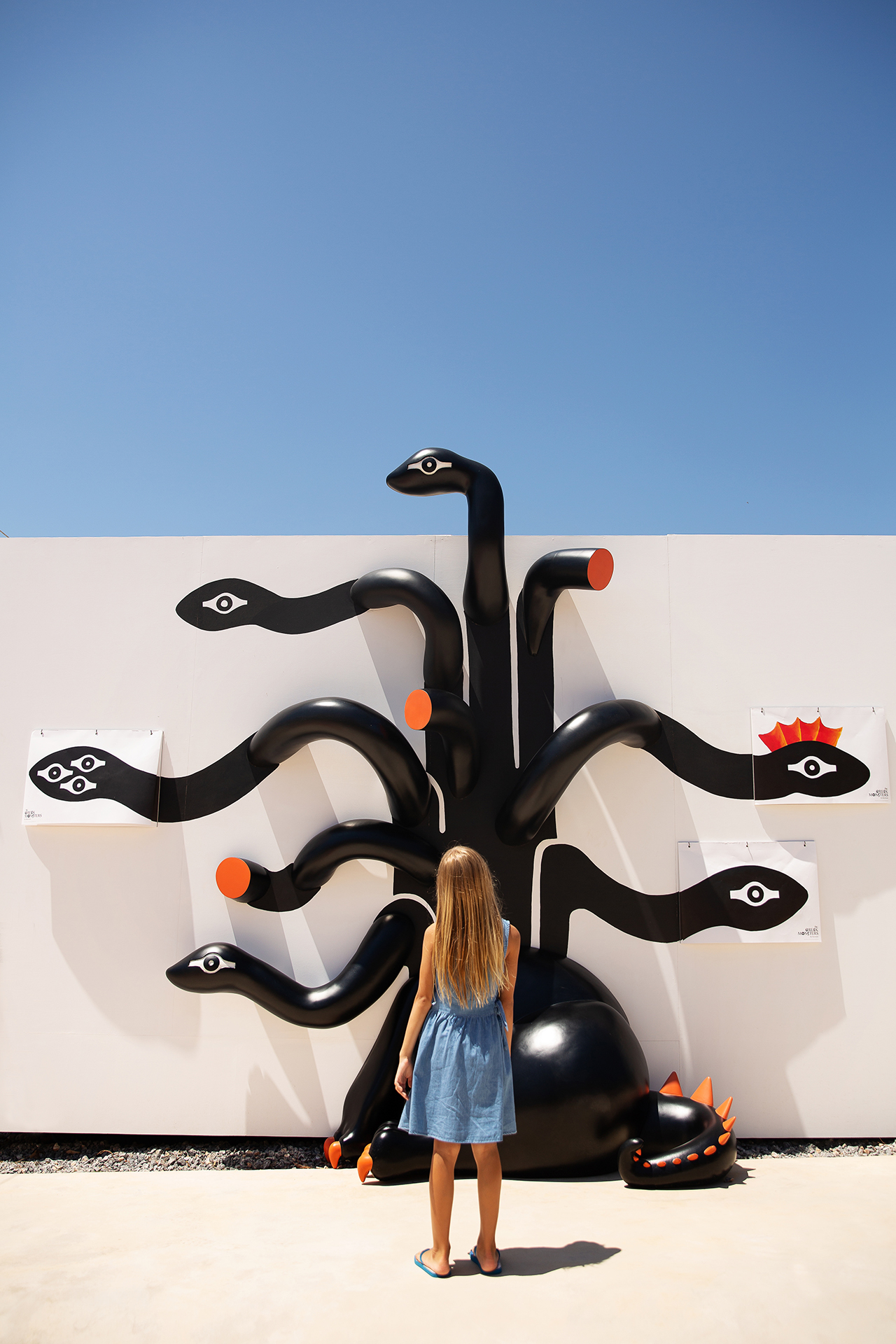 A girl standing in front of a black Greek art sculpture