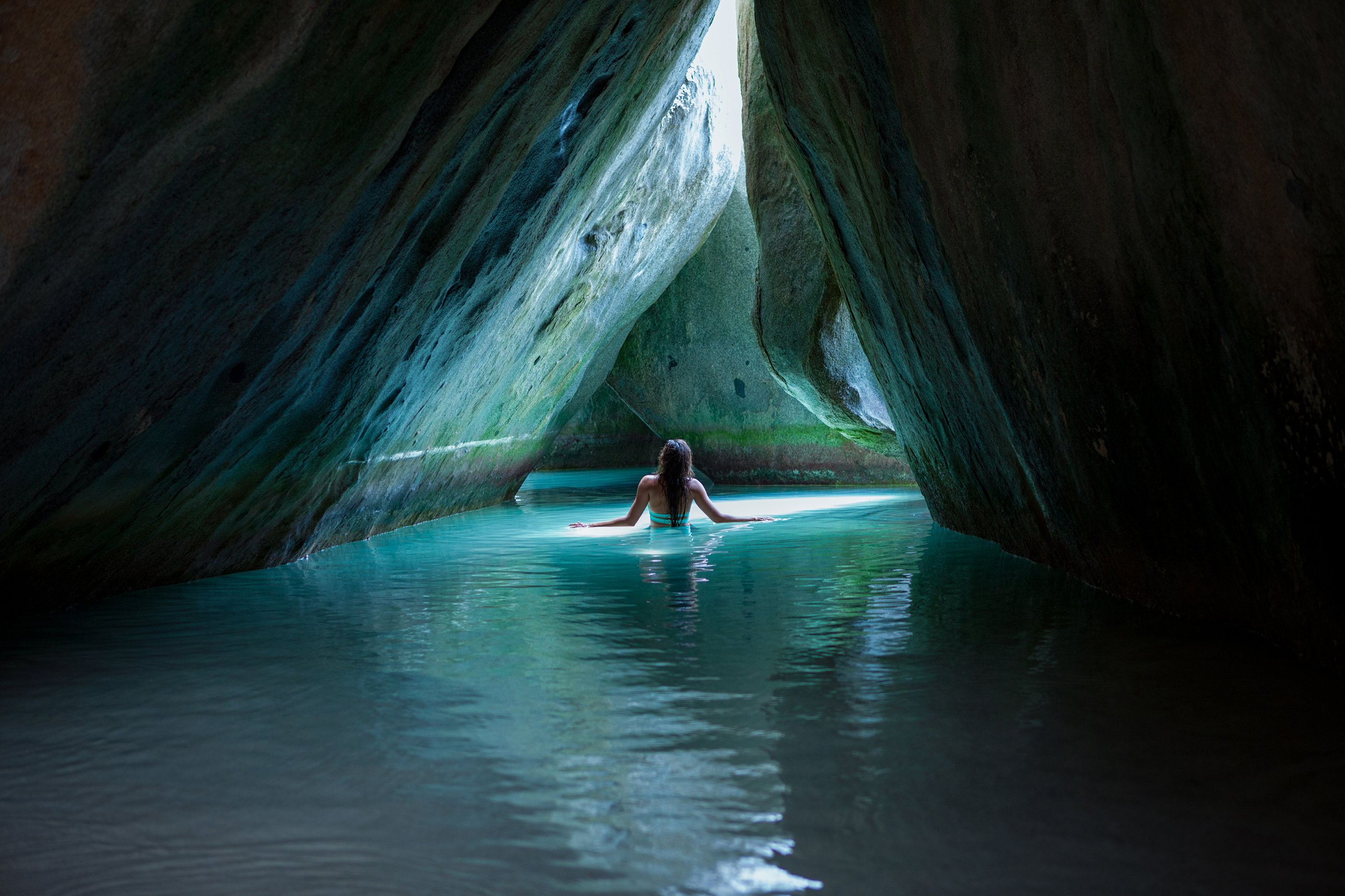 A woman walking through a grotto at the Baths of Virgin Gorda