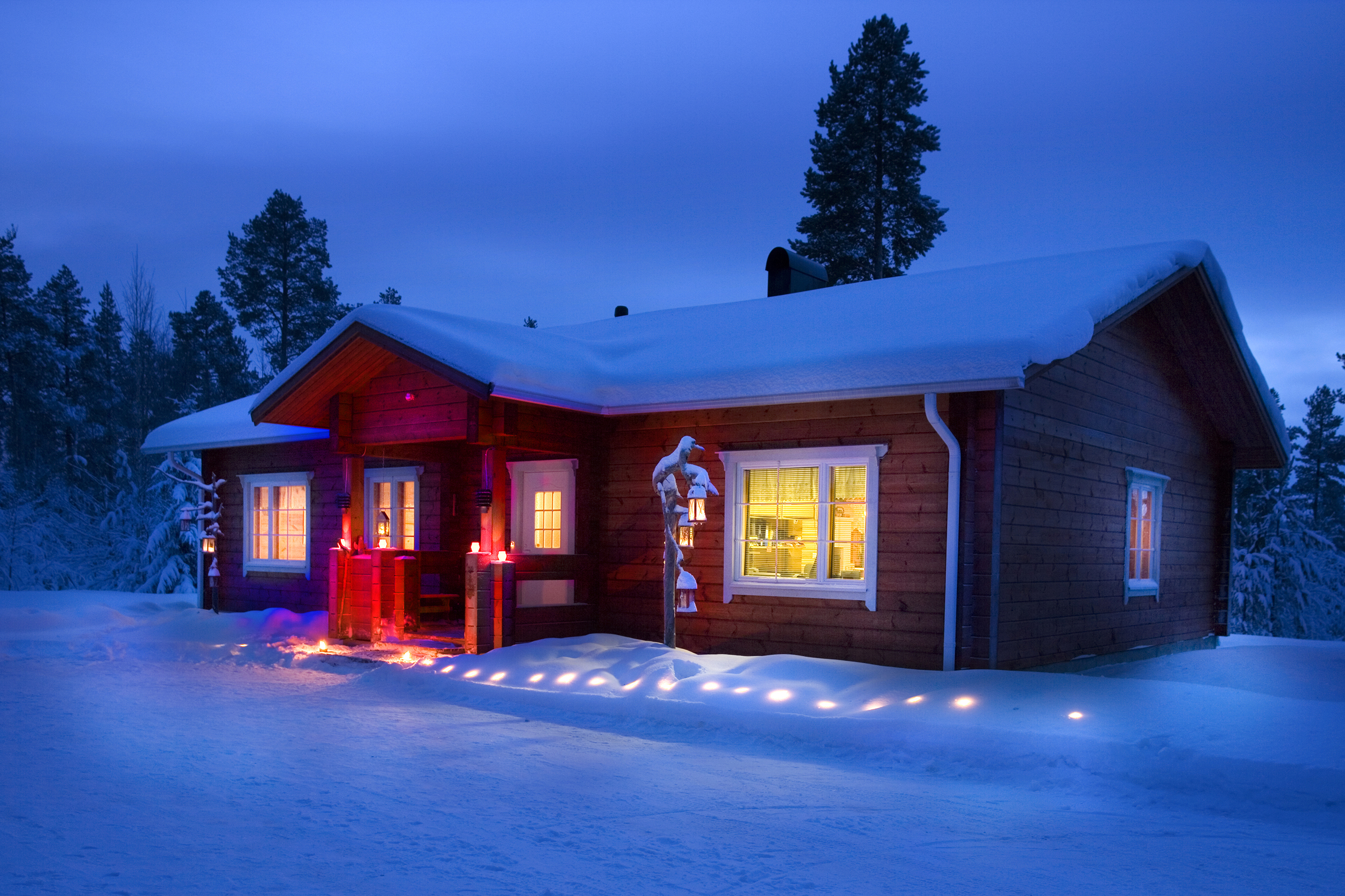 Red wooden snow covered hut in Finnish Lapland