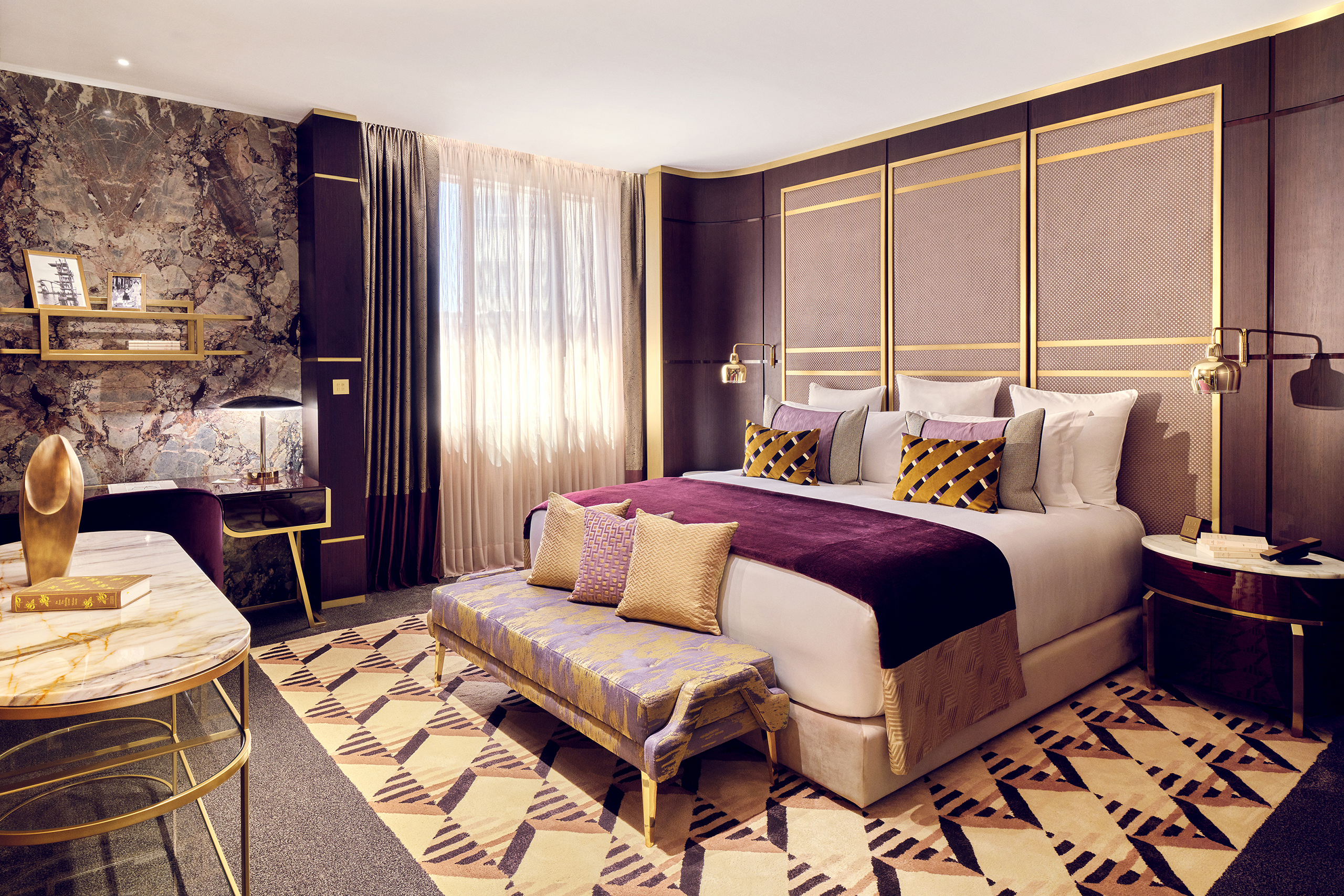 A lavish pruple and gold suite at Royal Mansour Casablanca featuring a plush bed, patterned soft furnishings and marble accents