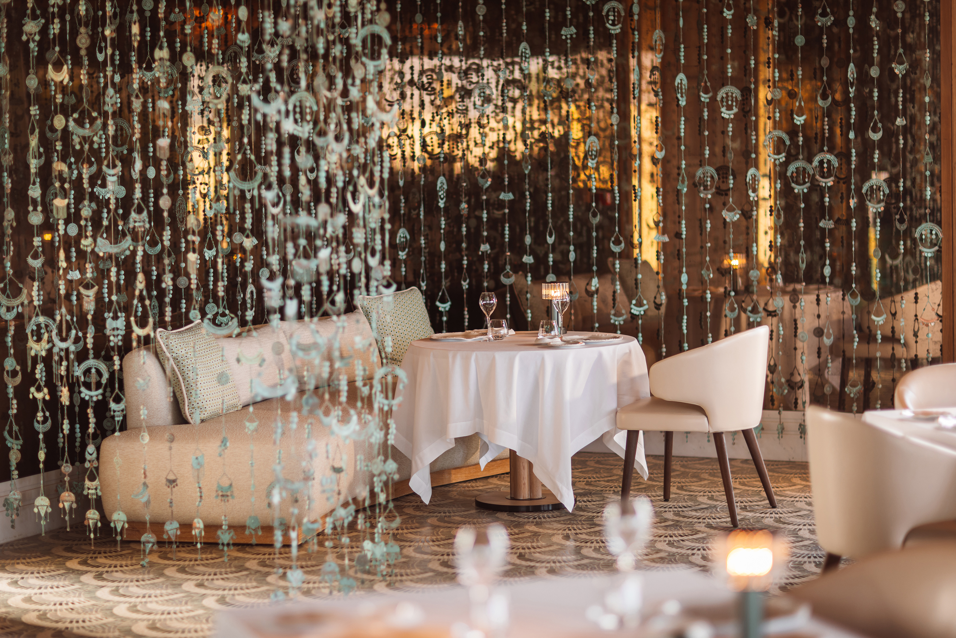 An intimate table in La Table Restaurant surrounded by hanging bead details