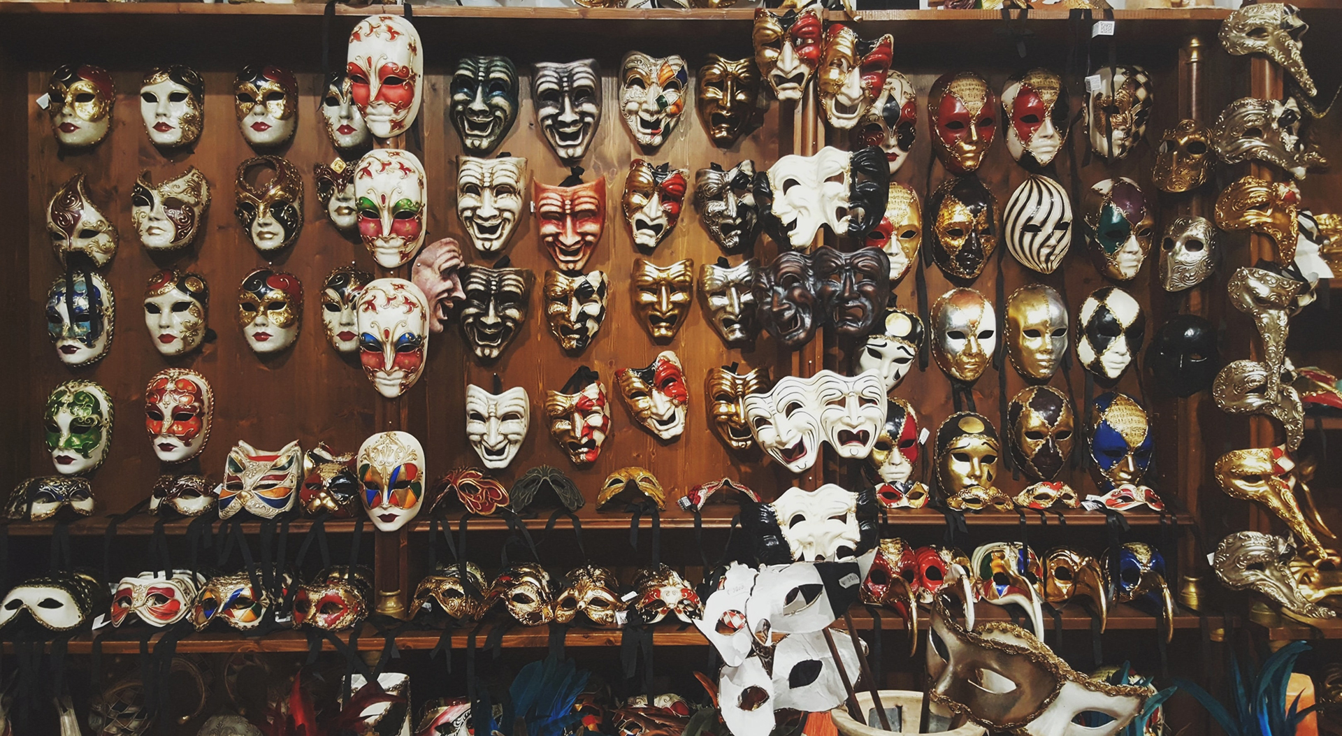 A wooden wall full of masquerade masks