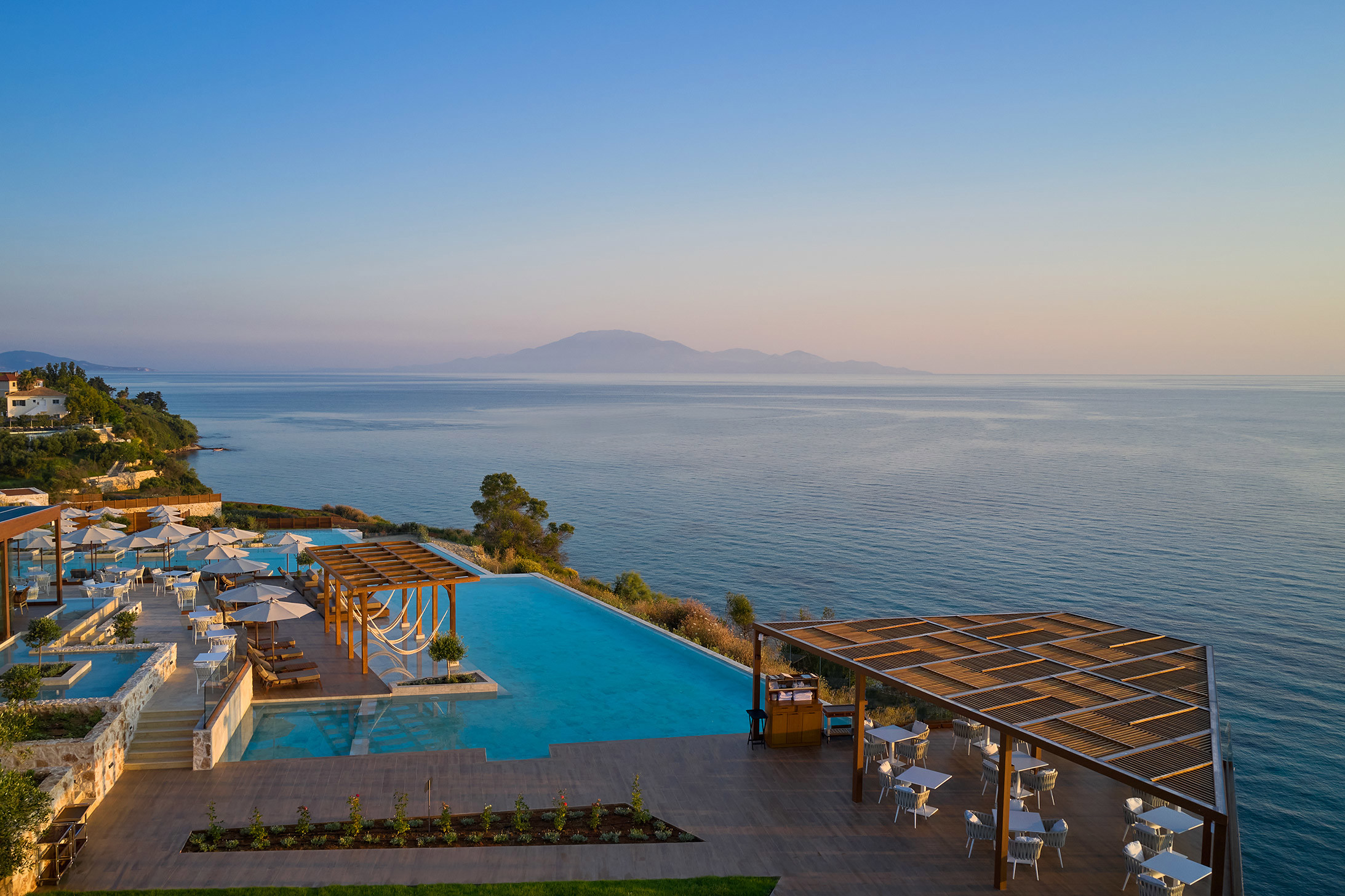 Main pool at sunset with views of islands on the horizon at Lesante Cape