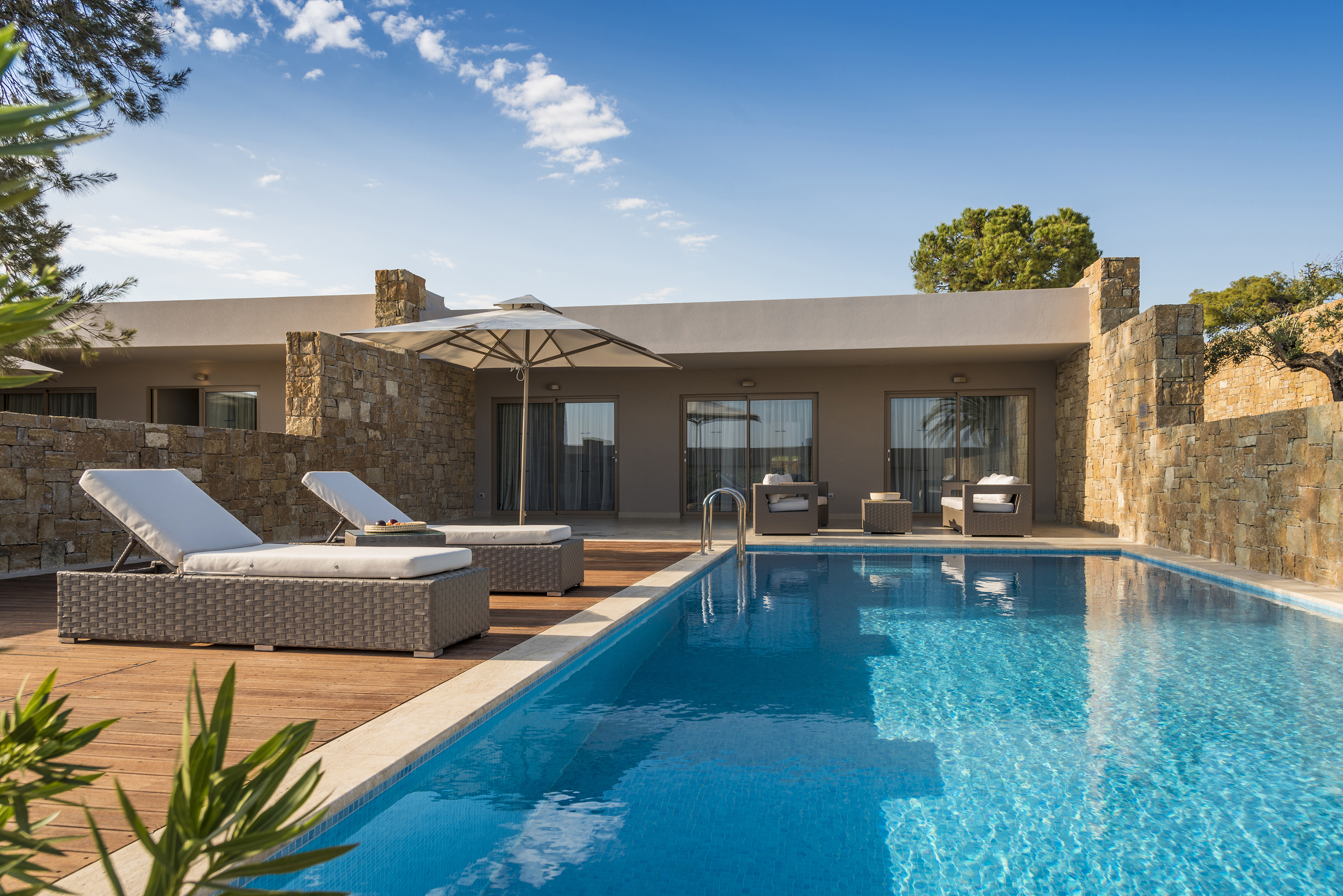 The exterior patio of a two bedroom bungalow at Ikos Olivia featuring a private pool and patio furniture 