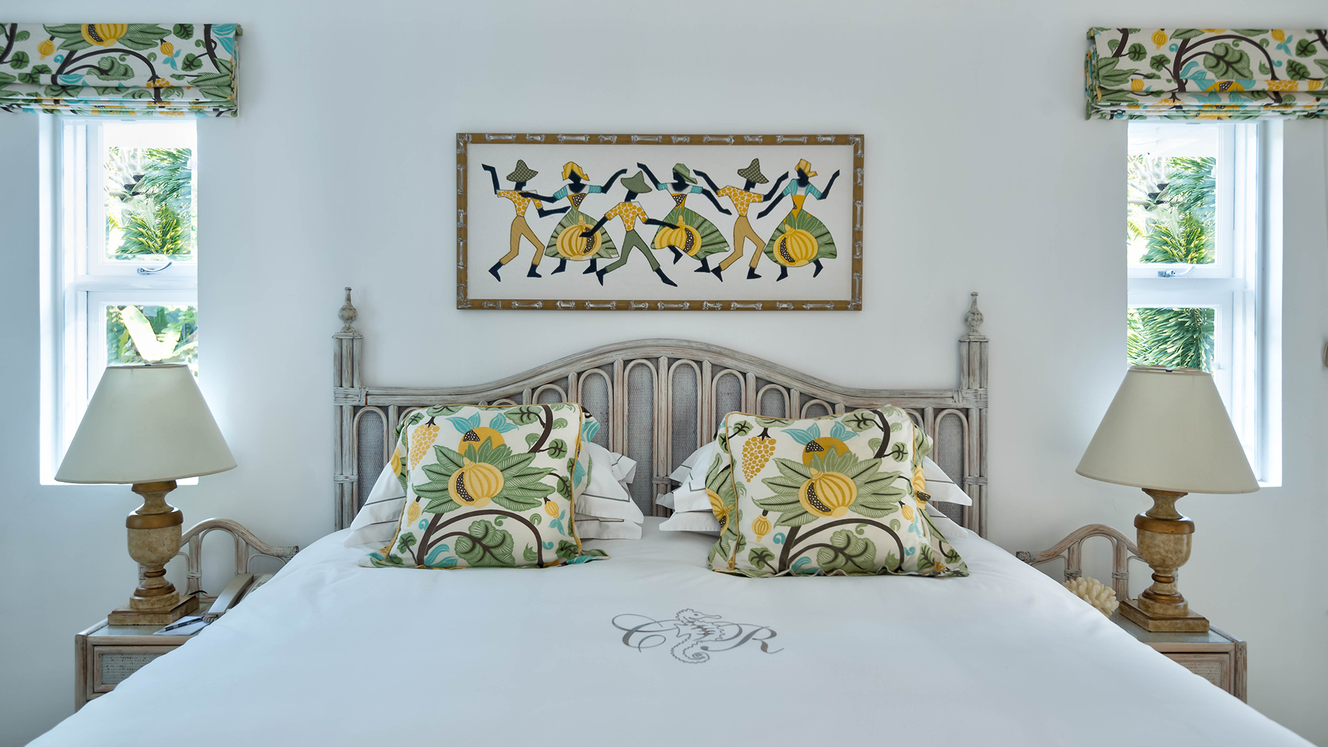 Yellow luxury cottage room bed with traditional artwork at Coral Reef Club