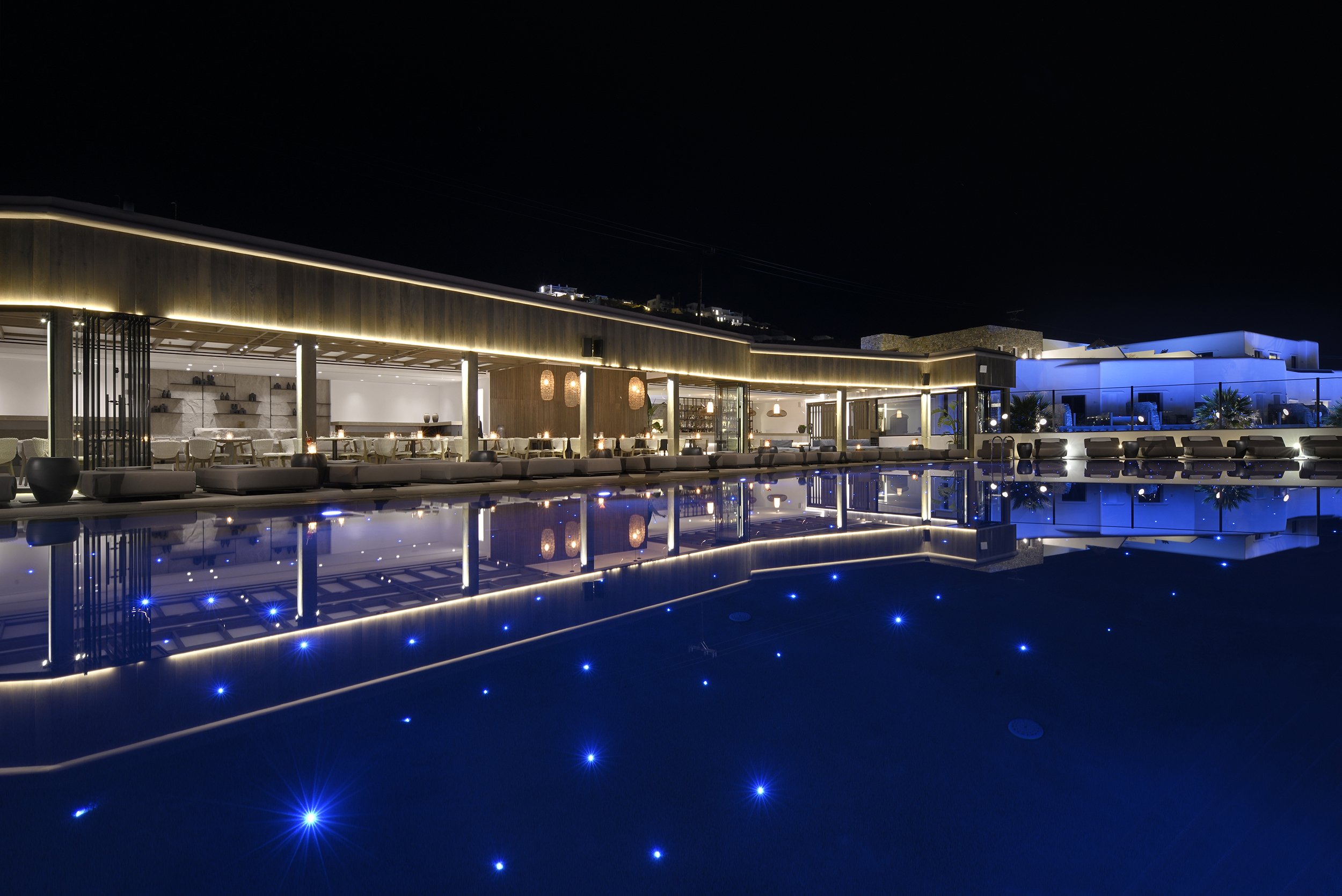 Nightime view of the main pool and Cove Restaurant at Aeonic Suites & Spa