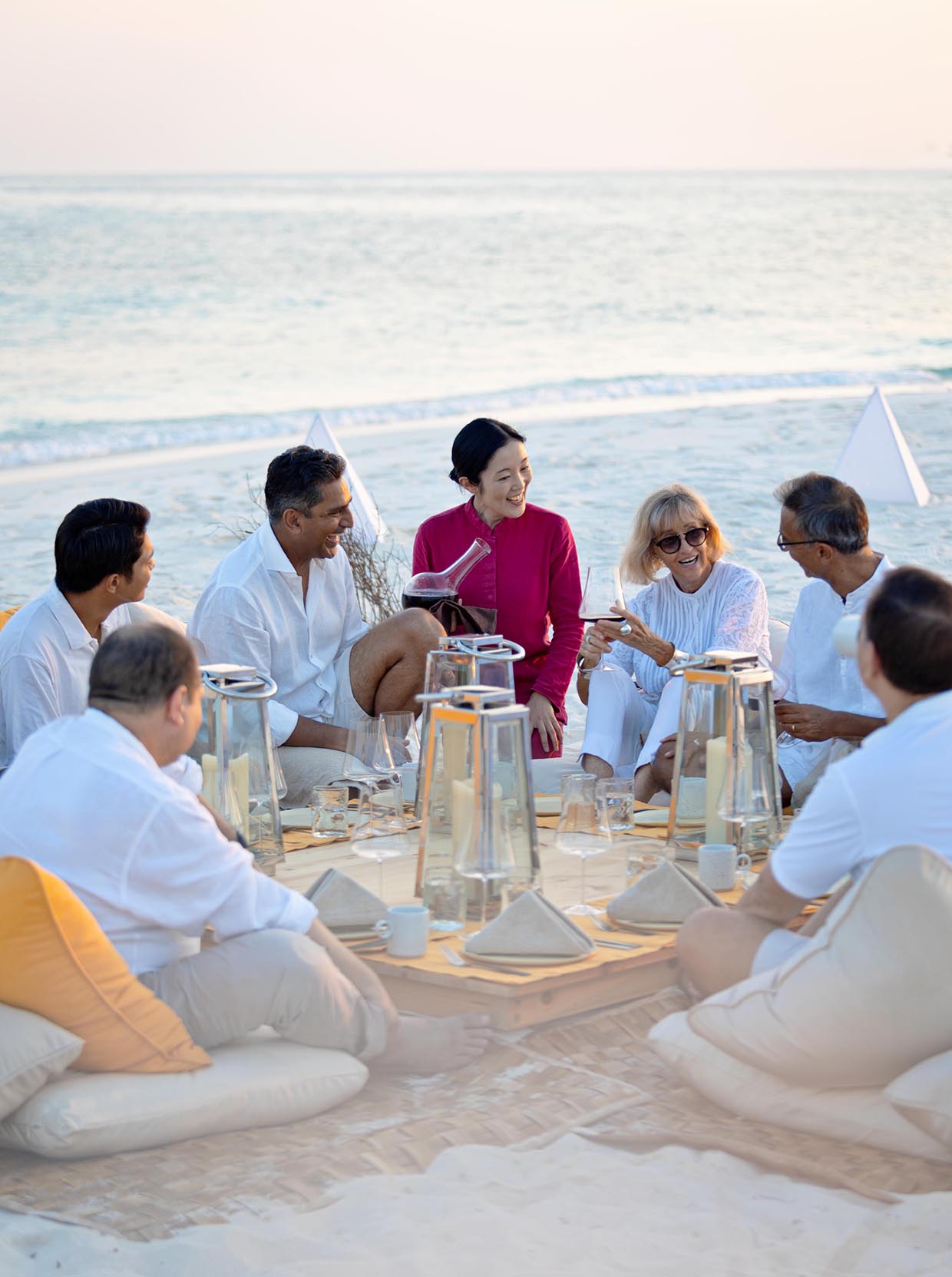 Indian Ocean, Maldives, Soneva Secret, group of people talking and waiting to dine on the beach
