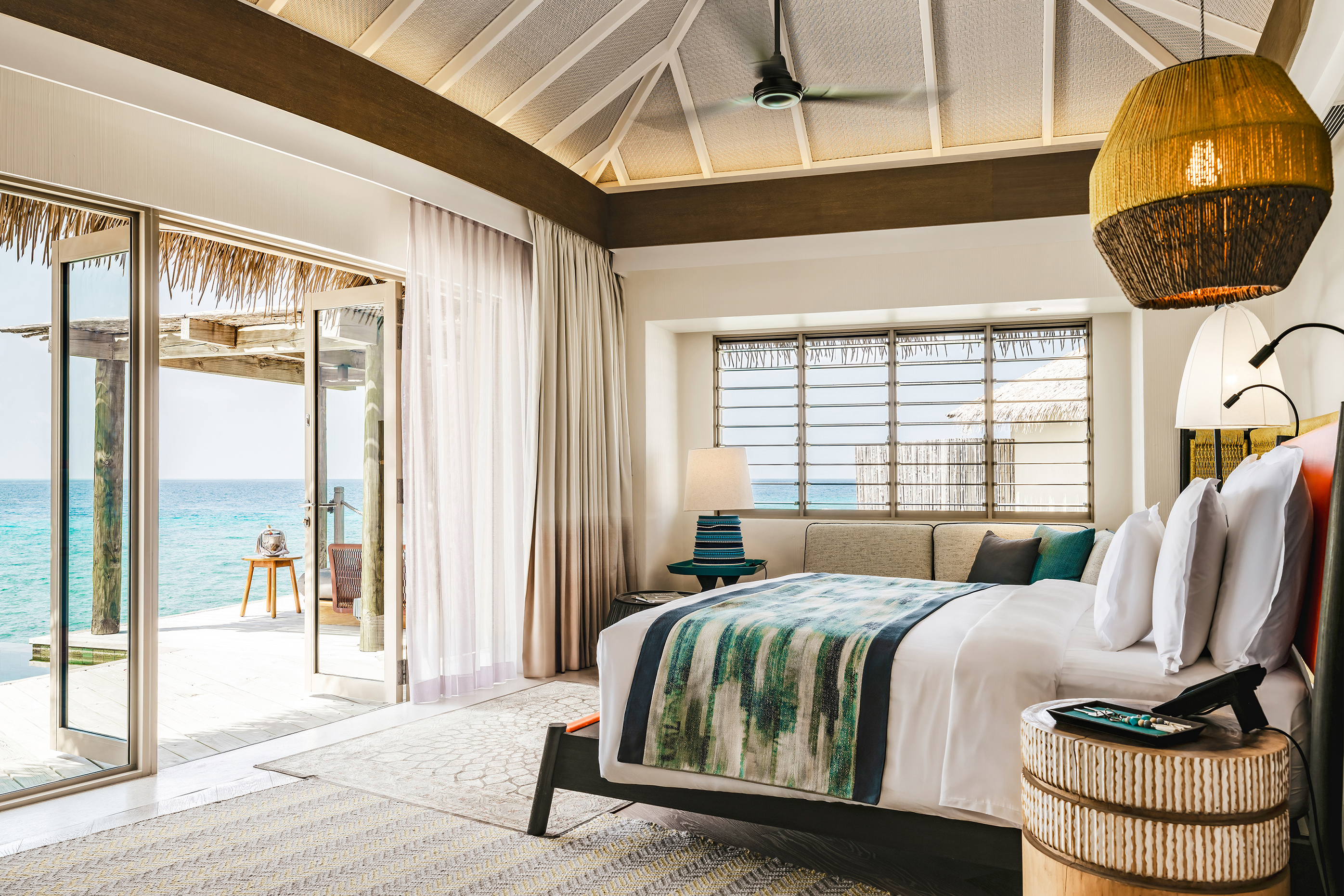 Luxurious overwater villa at InterContinental Maldives with ocean view, modern decor, and private deck access.