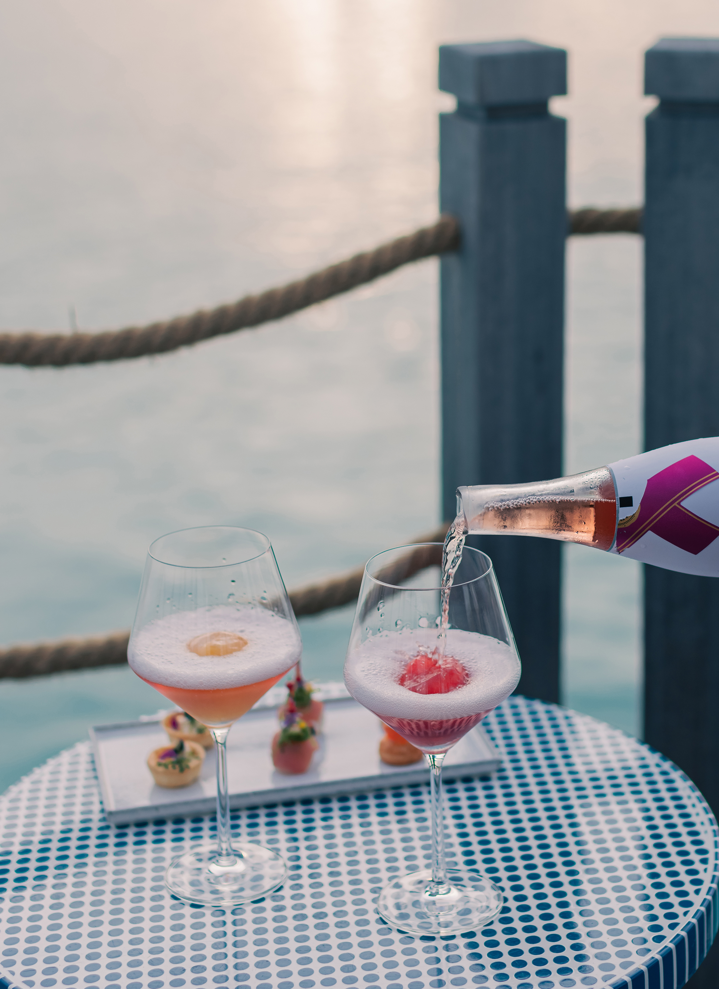 Luxurious waterfront dining at InterContinental Maldives with sparkling wine and gourmet appetizers.