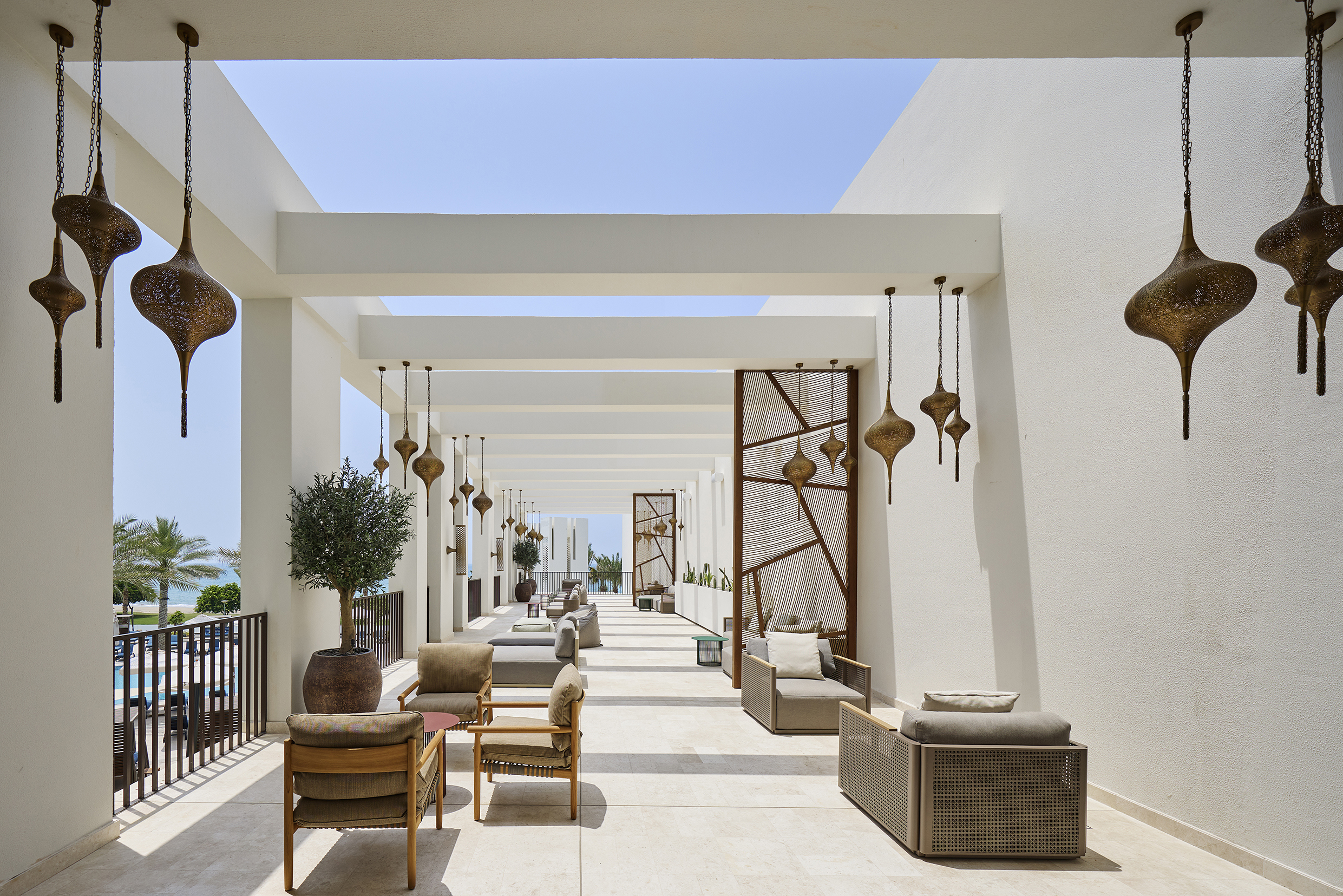 The whitewashed spa terrace of Mandarin Oriental Muscat featuring chic furniture and traditional lanterns