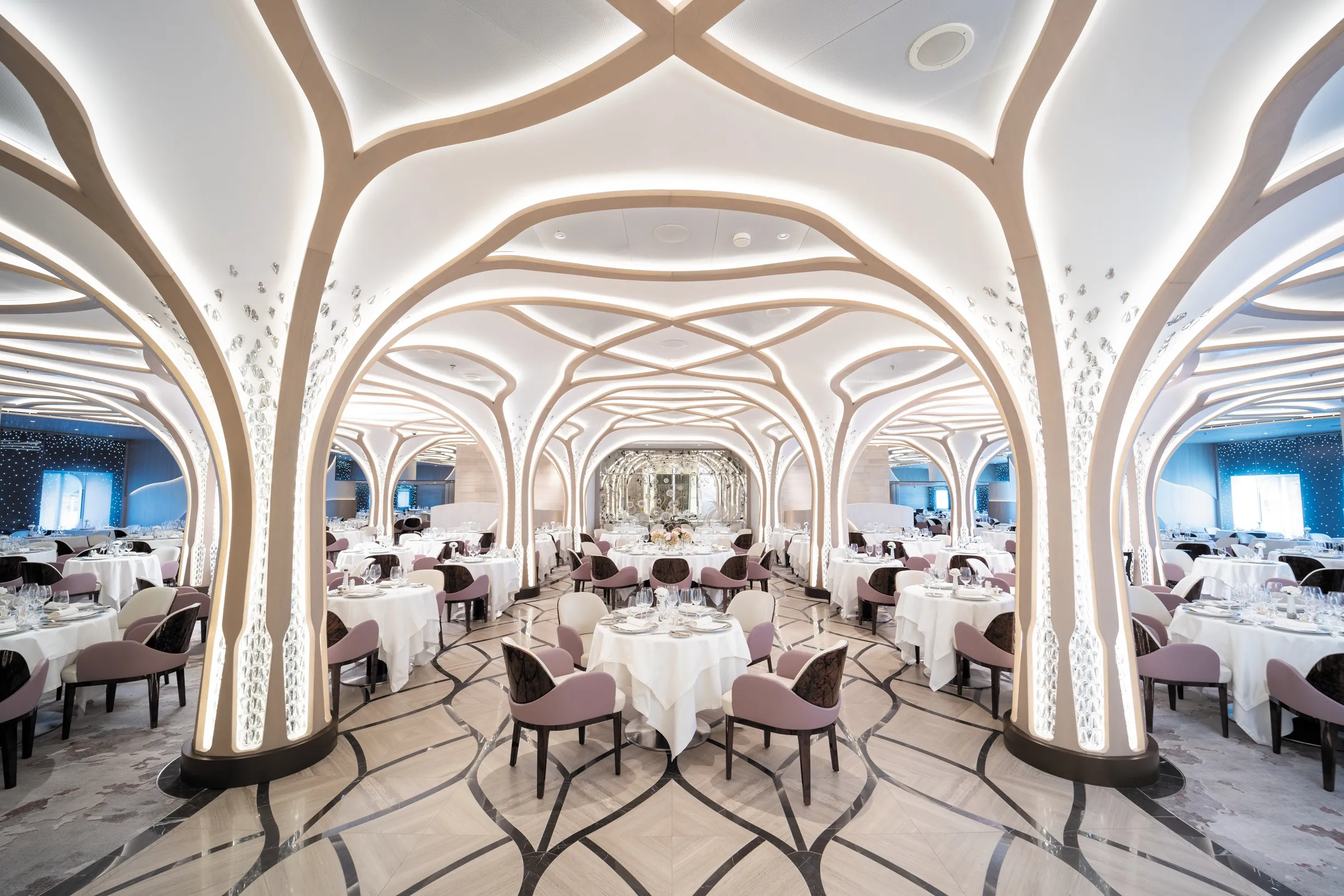Luxurious modern Compass Rose restaurant with ornate ceiling design and elegant table settings.