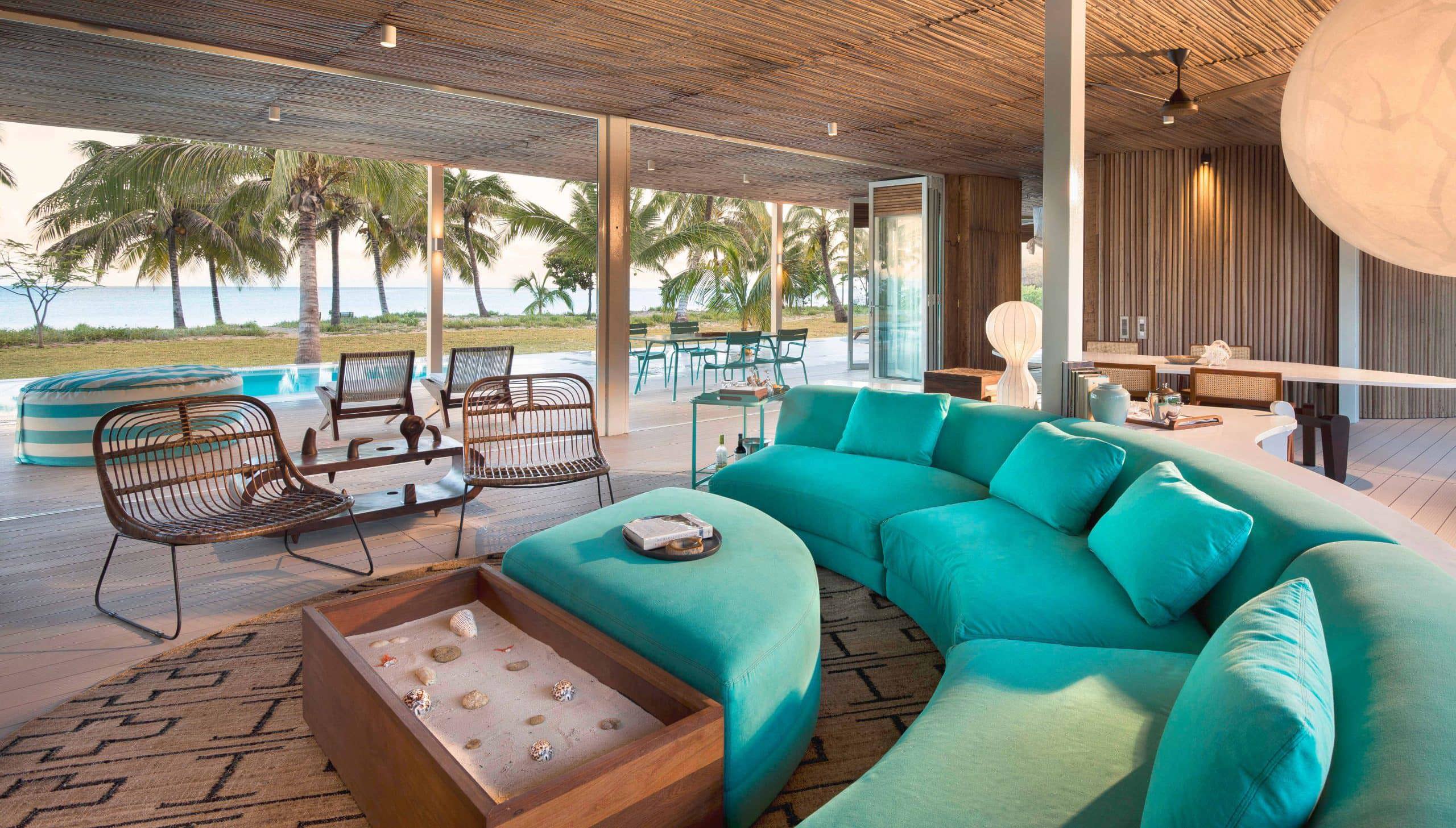 Curved blue sofa and chairs in the lounge of a villa at Miavana