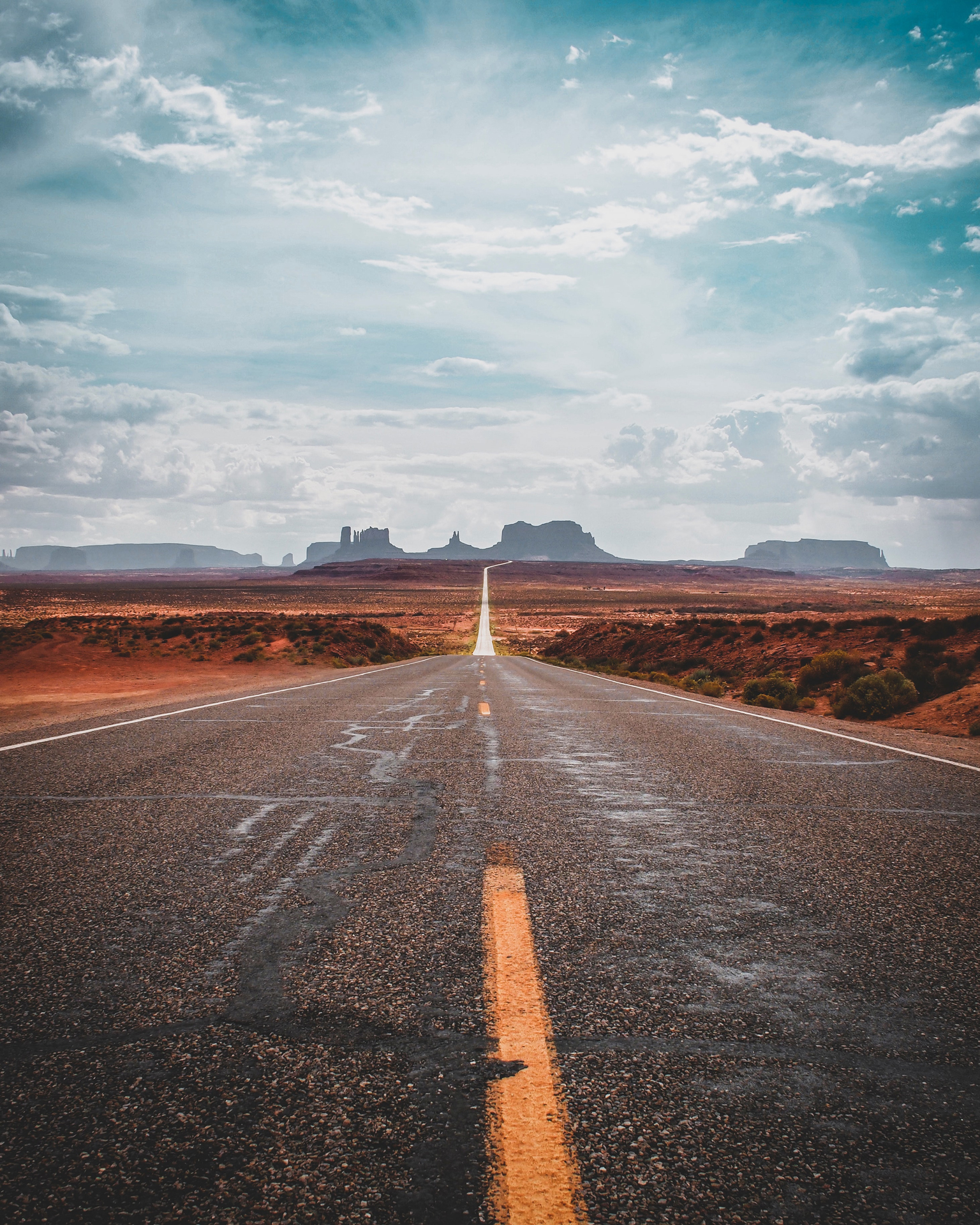 Grey asphalt road under a cloudy sky