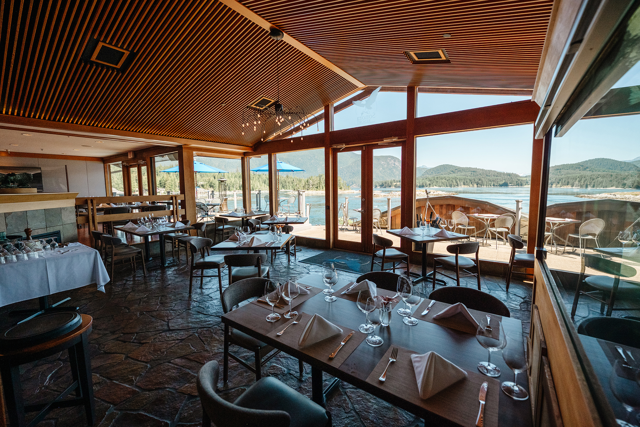 The Tyee restaurant at Sonora Lodge with high ceilings, large windows and dining tables set up for dinner