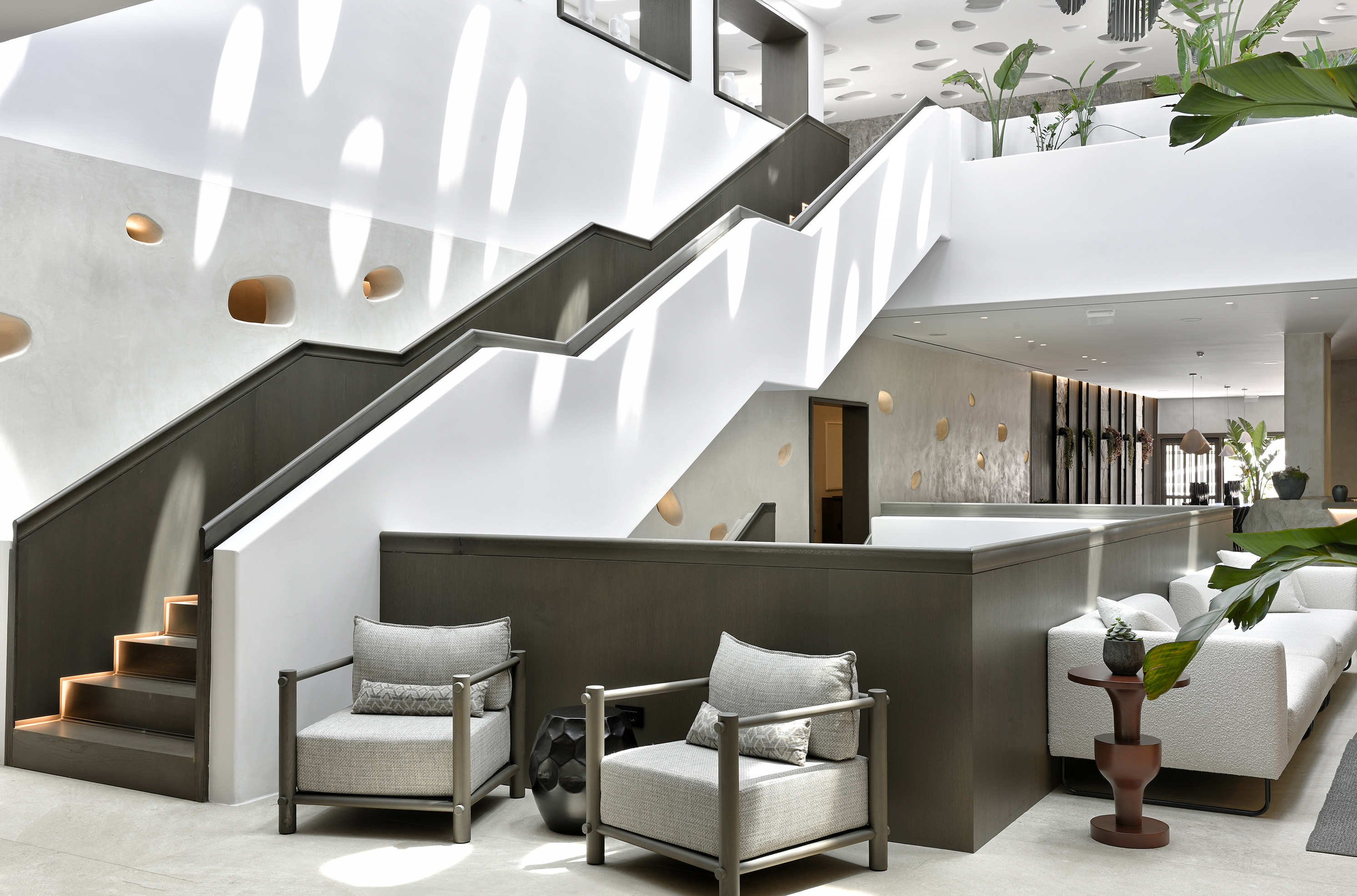 Staircase and two chairs in the lobby of Aeonic Suites & Spa