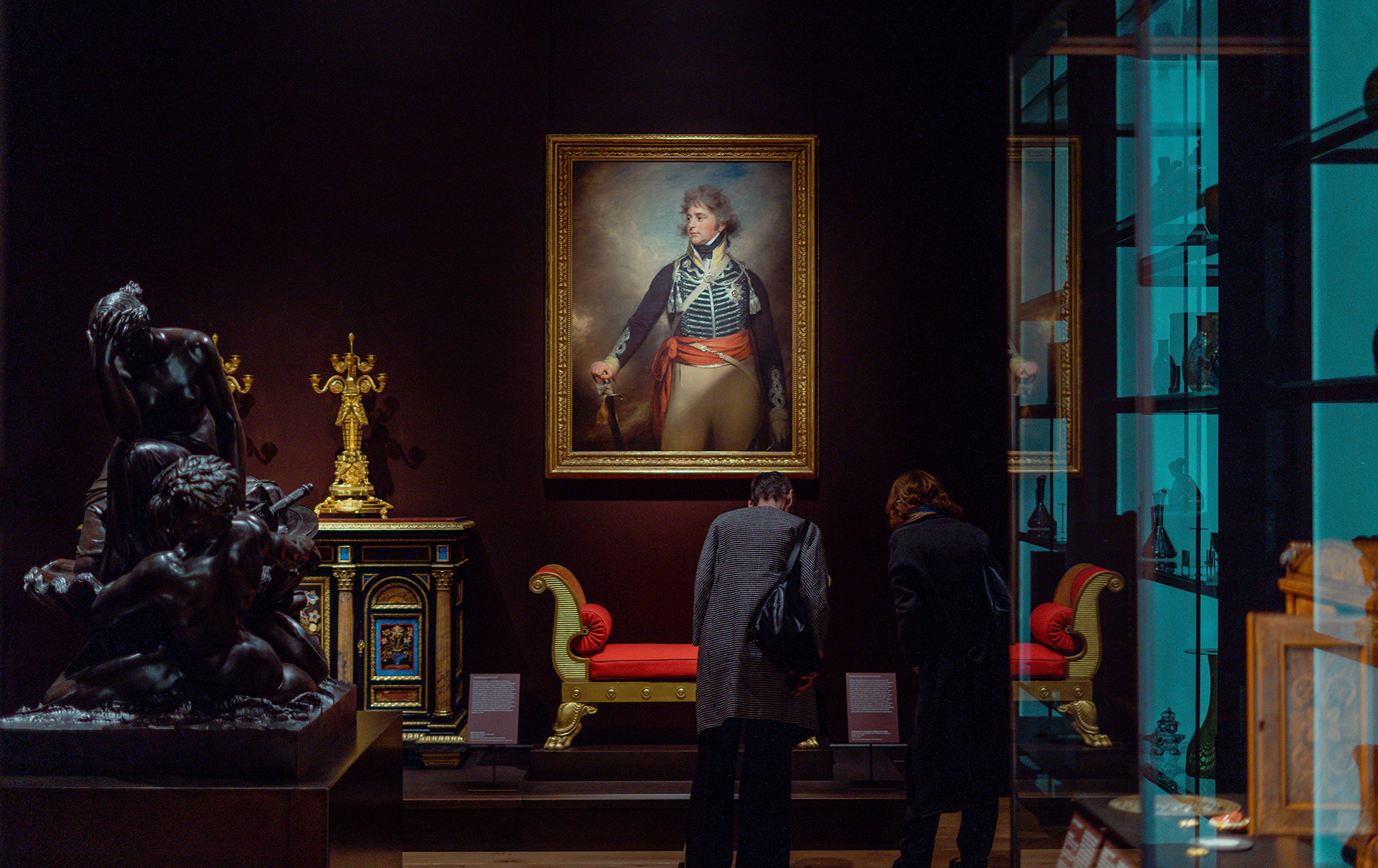 Two people viewing art in a dark room