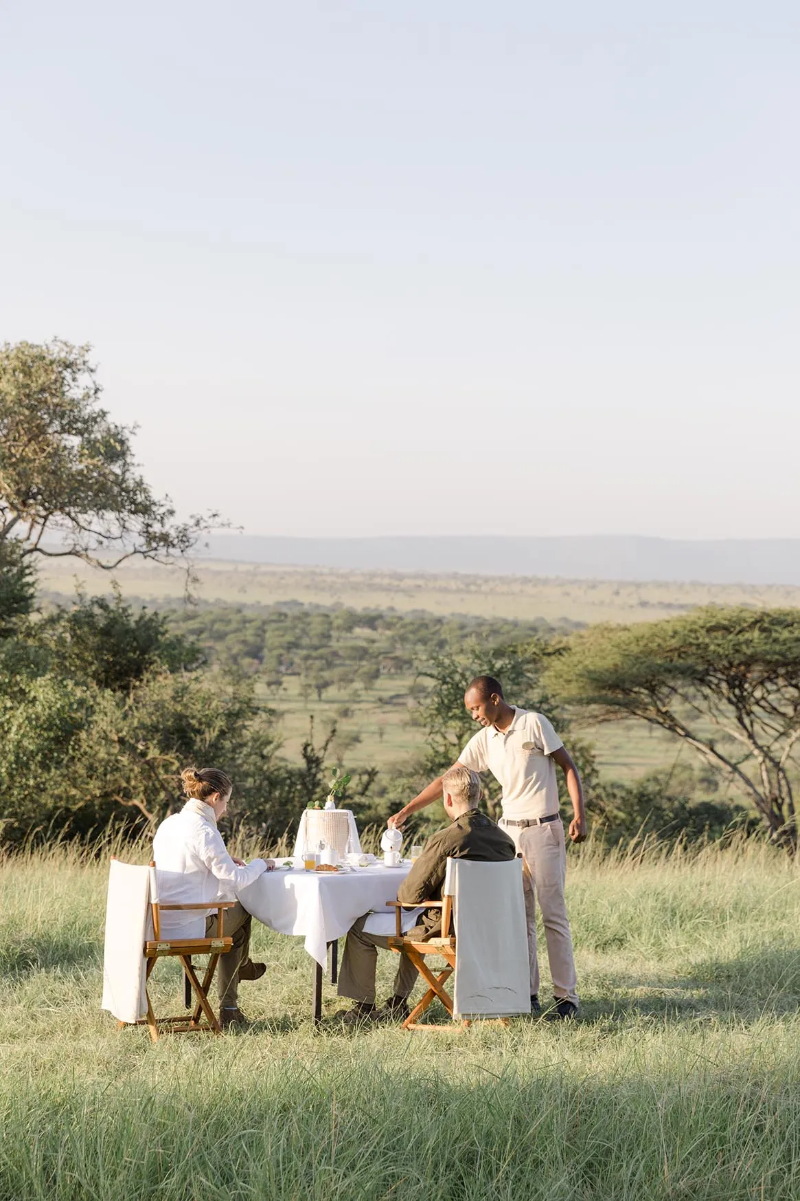 Africa, Tanzania, Serengeti Bushtops, couple having breakfast in an al fresco private dining experience