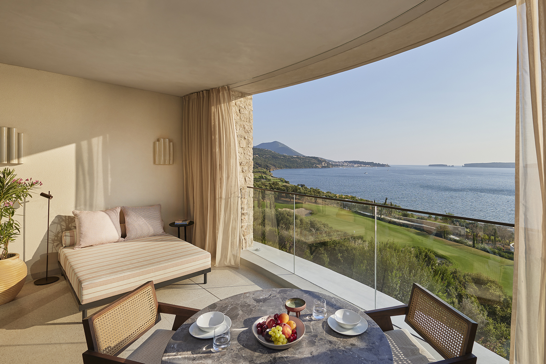 Europe, Greece, Mandarin Oriental Costa Navarino, table and day bed on terrace looking out to sea
