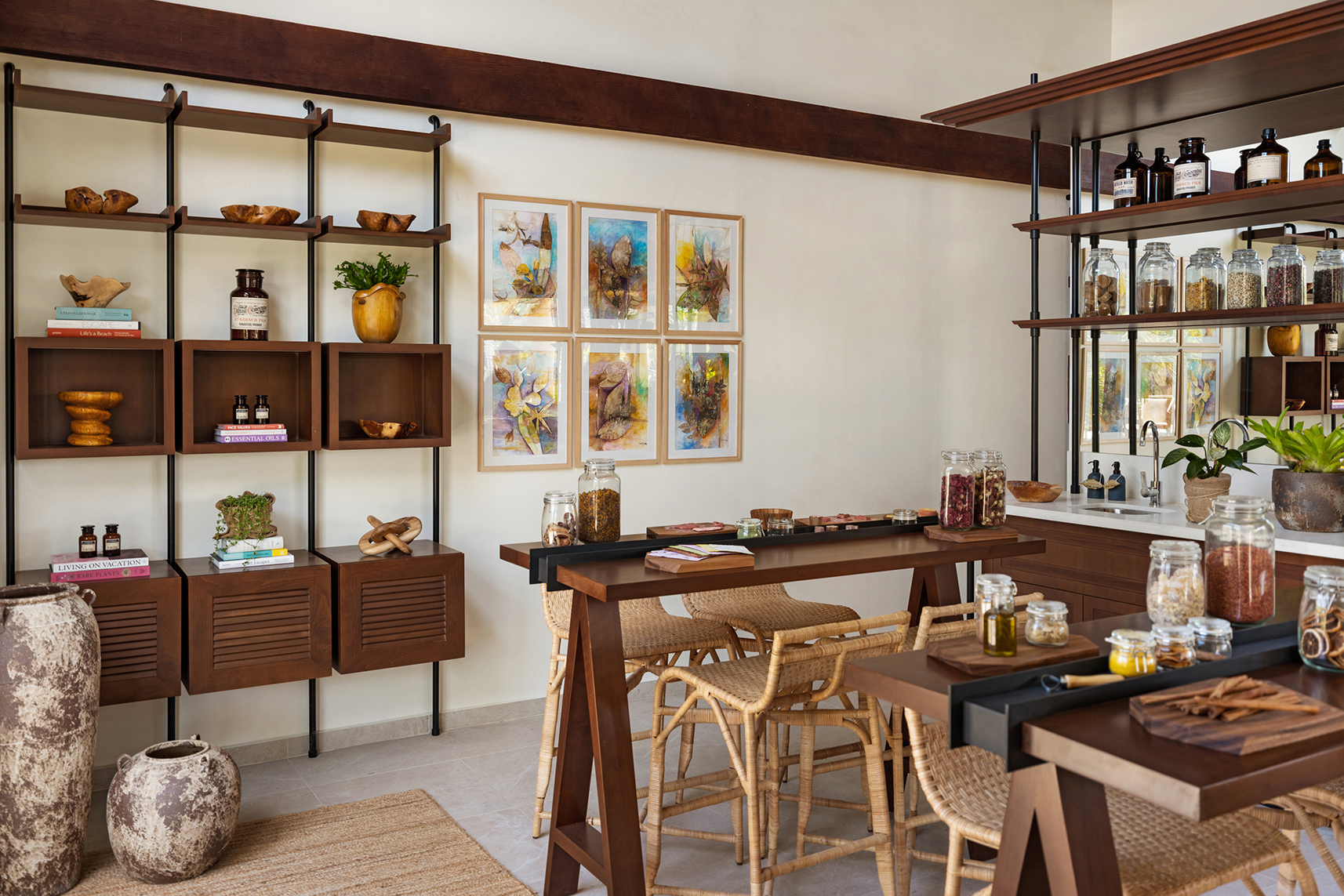 A light and ariy space with high ceiling beams is filled with tables, chairs and cooking equipment