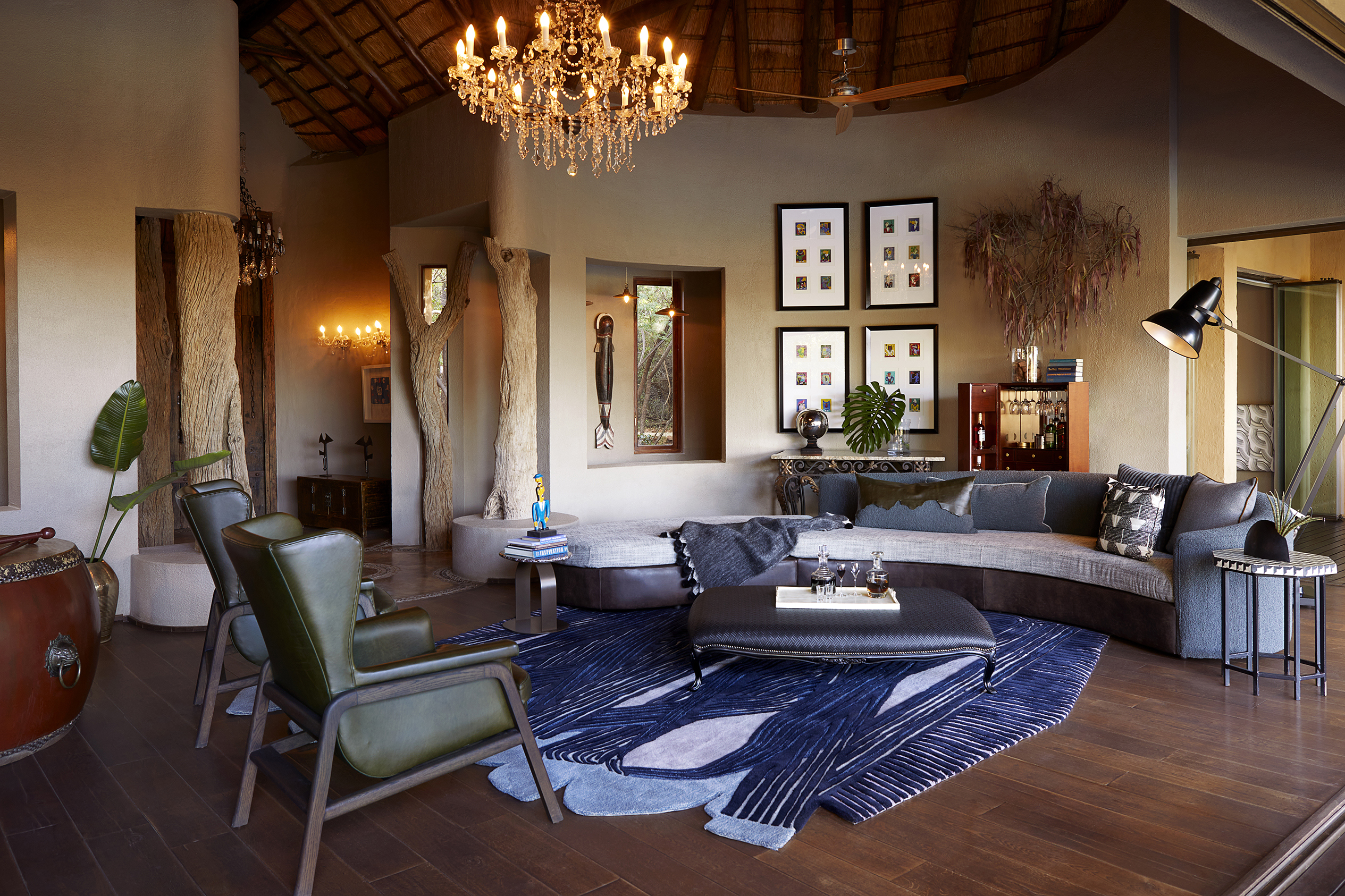 A relaxing lounge are featuring lavish decor including comfy sofas, a chandelier and wall art