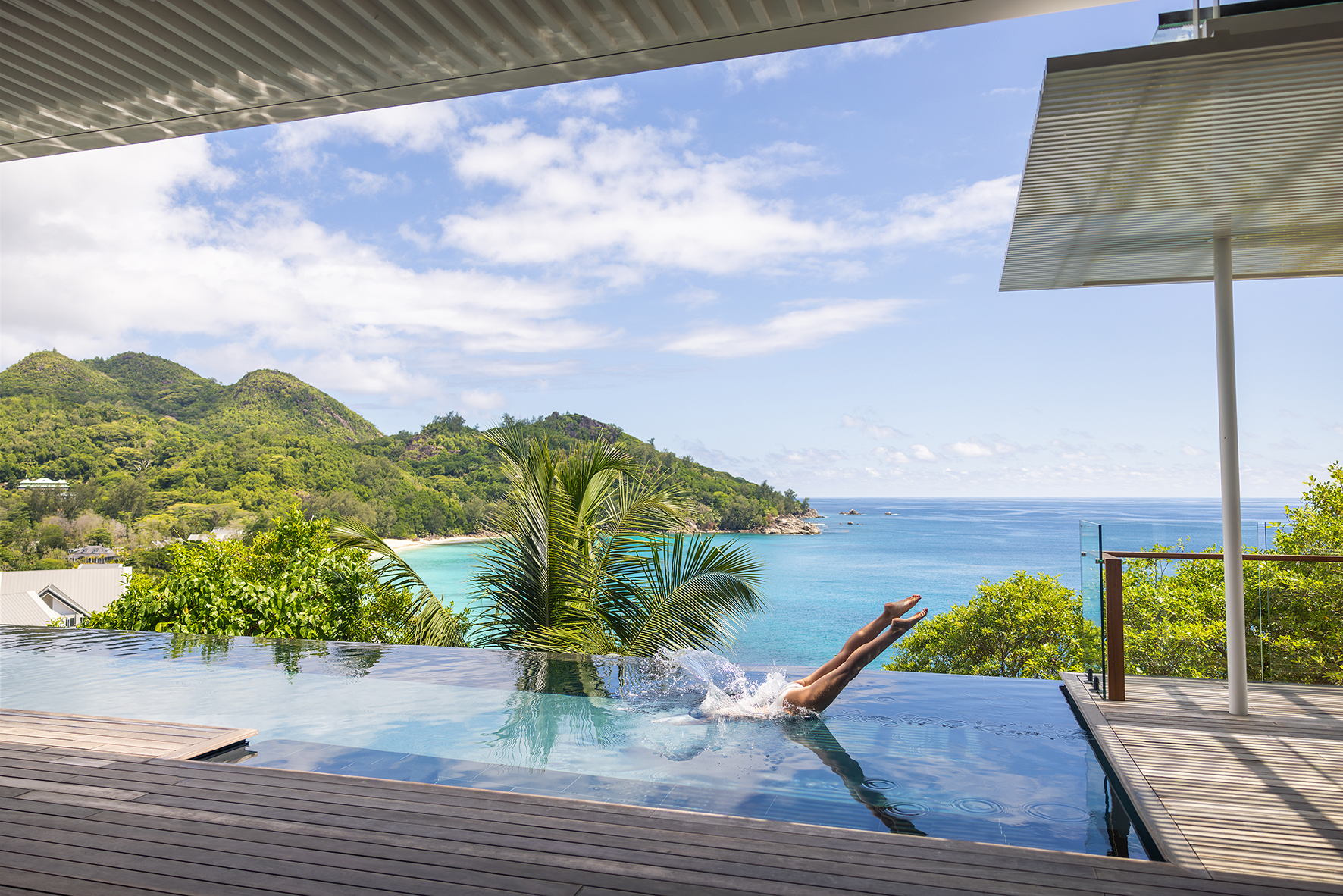 Indian Ocea, Seychelles, Cheval Blanc, Panorama Hill Villa, woman divcing into private pool on terrace 