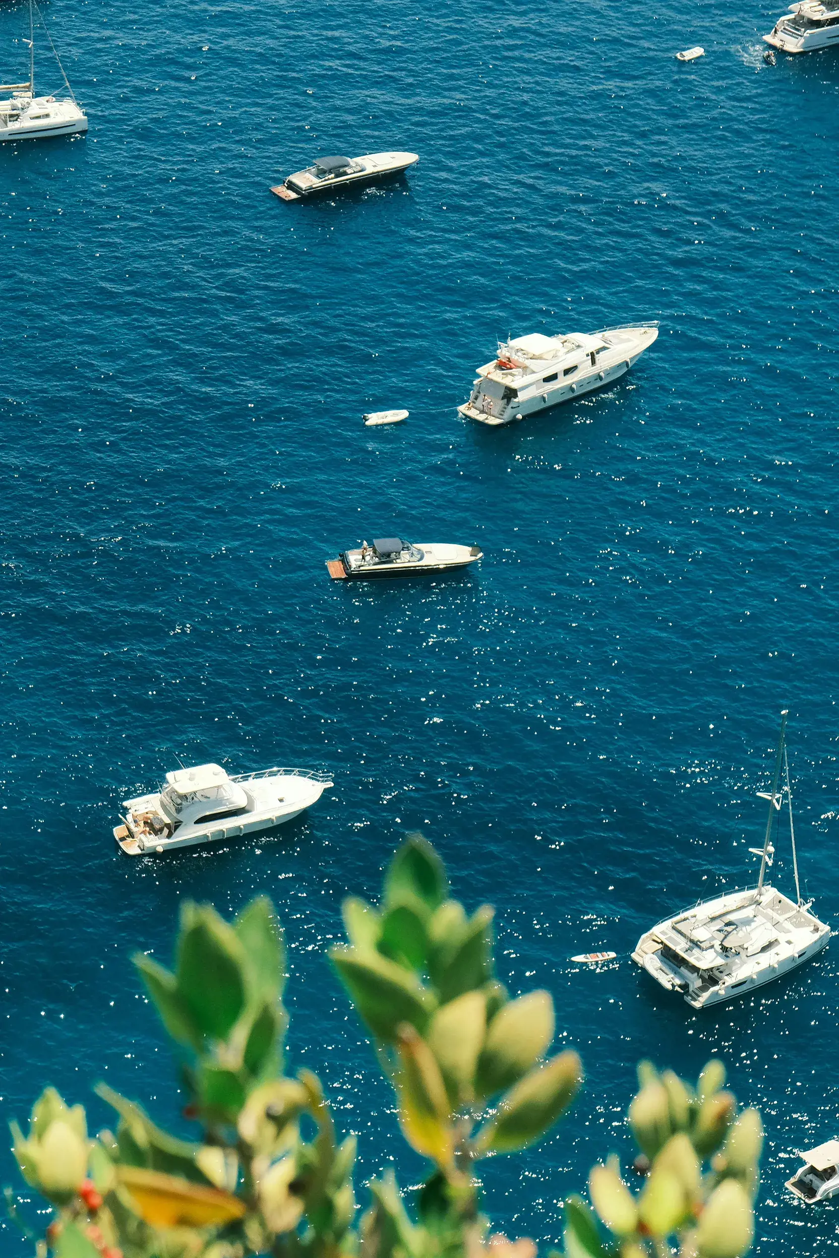 Luxury yachts and boats floating on the clear blue waters of the Amalfi Coast in Italy.
