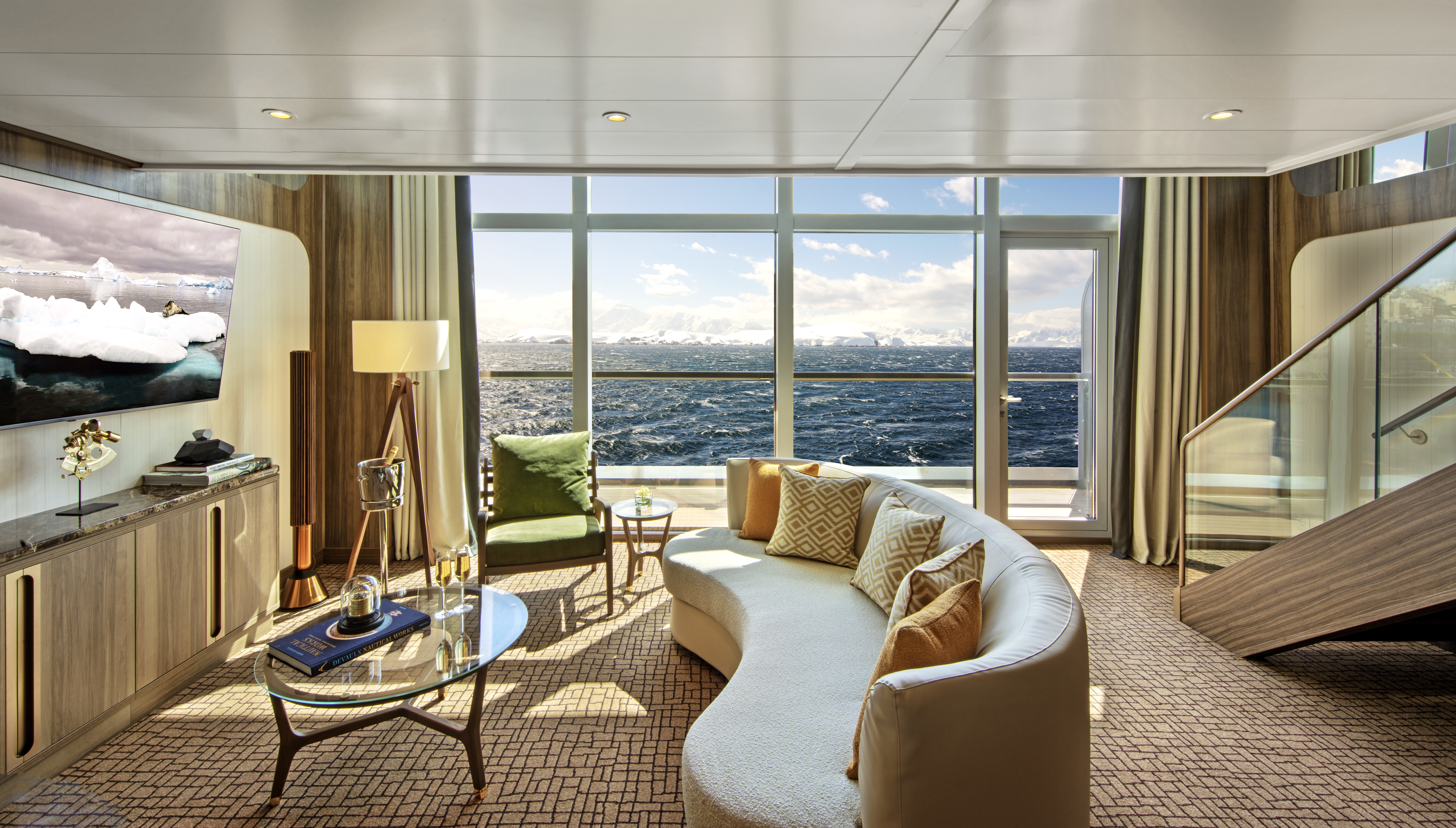 The opulent Wintergarden suite lounge aboard Seabourn Venture featuring plush furnishings and floor-to-ceiling windows looking out to the icy landscape