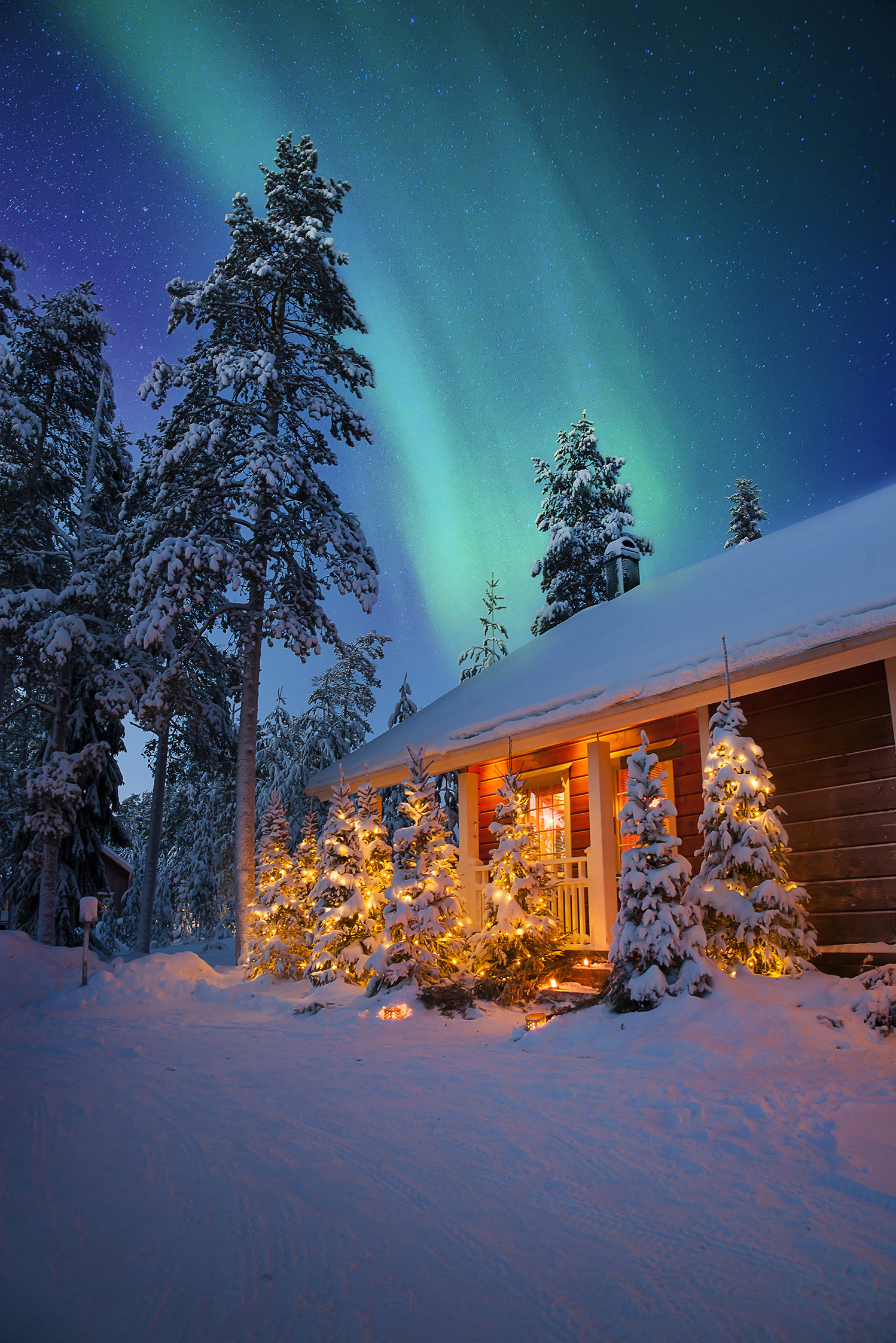Chalet covered in snow and northern lights