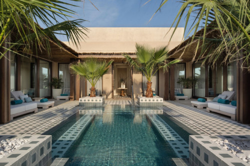 A large courtyard with tiled pool and green palms at either corner at Bab al Shams, A Rare Finds Desert Resort, Dubai