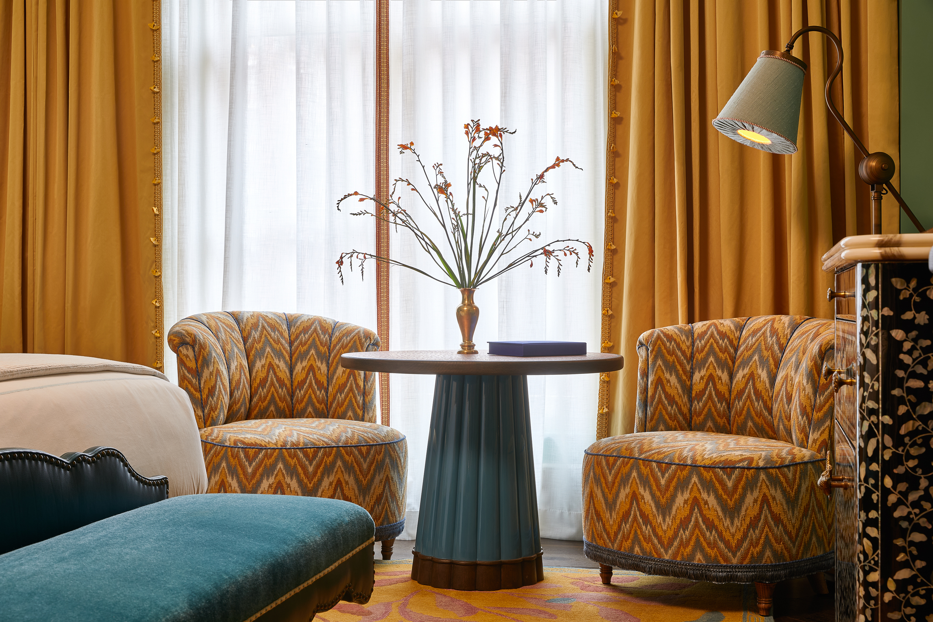Table with faux flowers in vase and patterned chairs