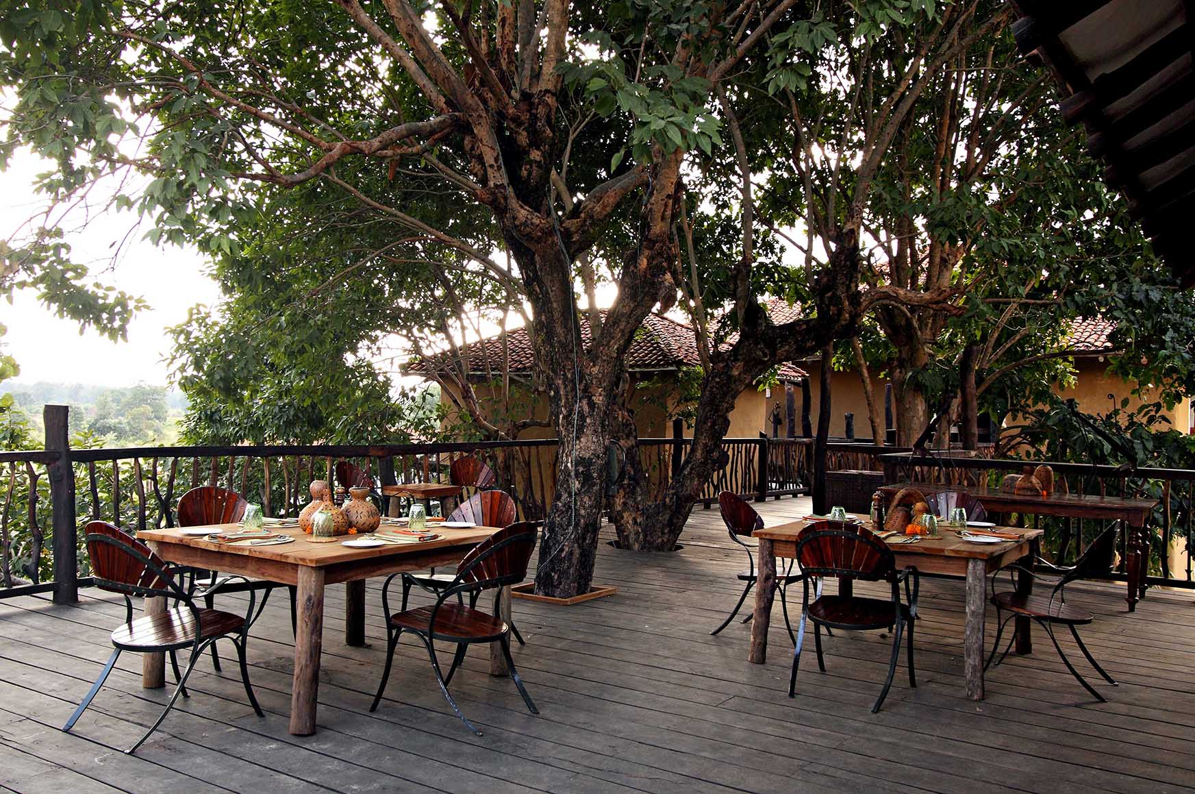 Asia, India, Samode Safari Lodge, outdoor dining tables on raised decking among the trees