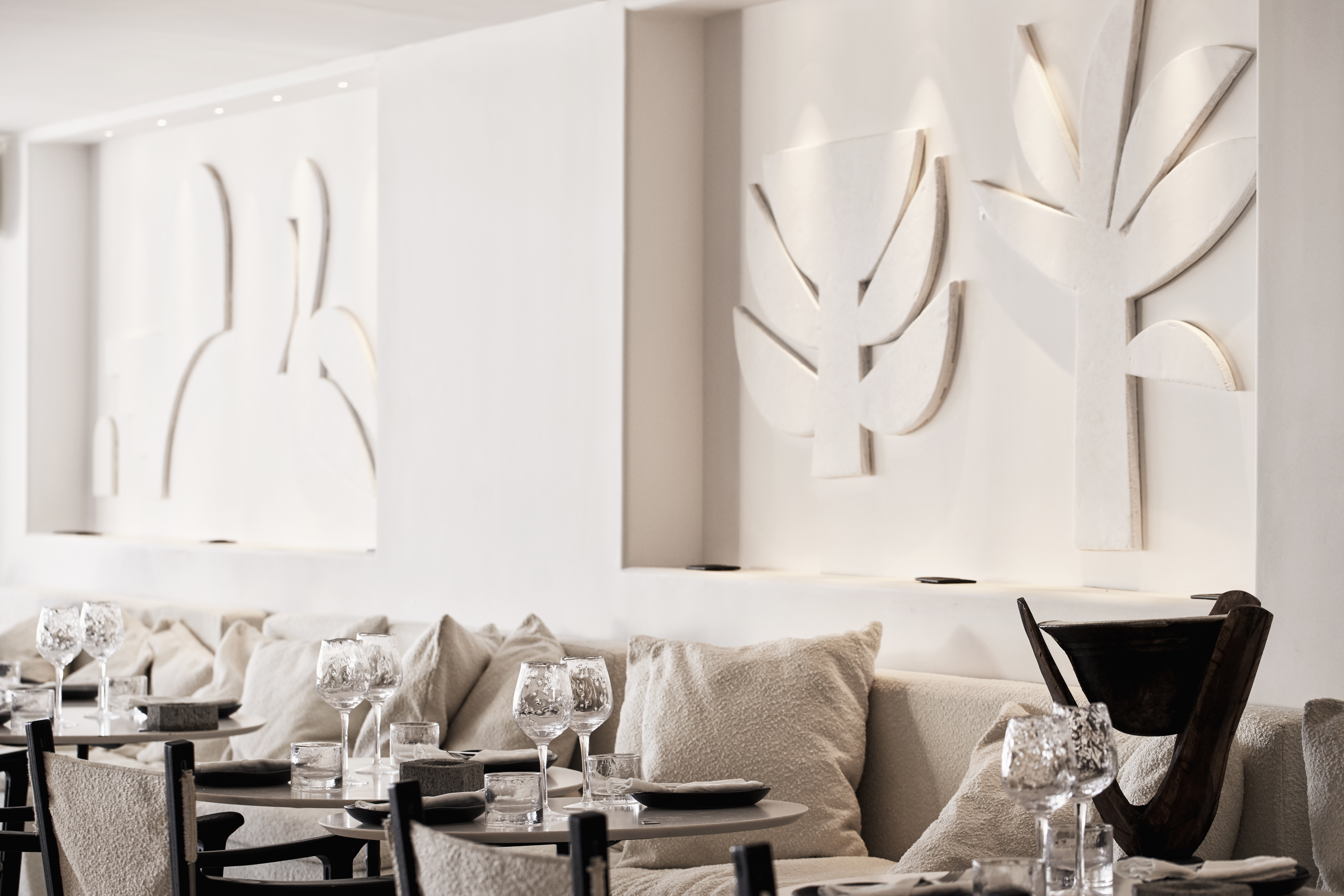 Seating against the white sculptual walls of O Restaurant at Myconian O