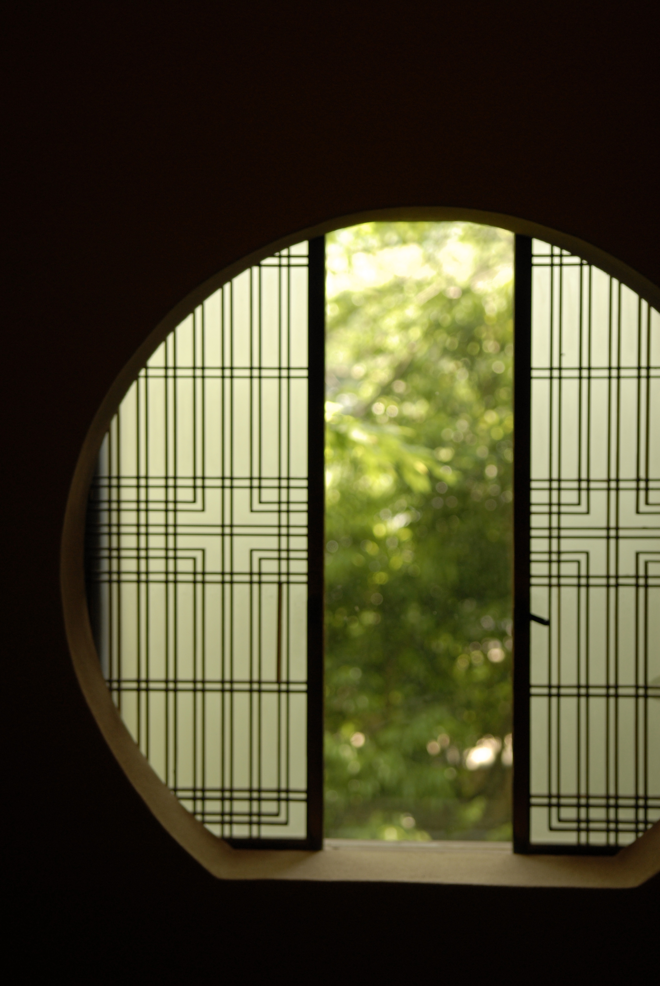 A decorative circular window at Gora Kadan looking out to a jungle