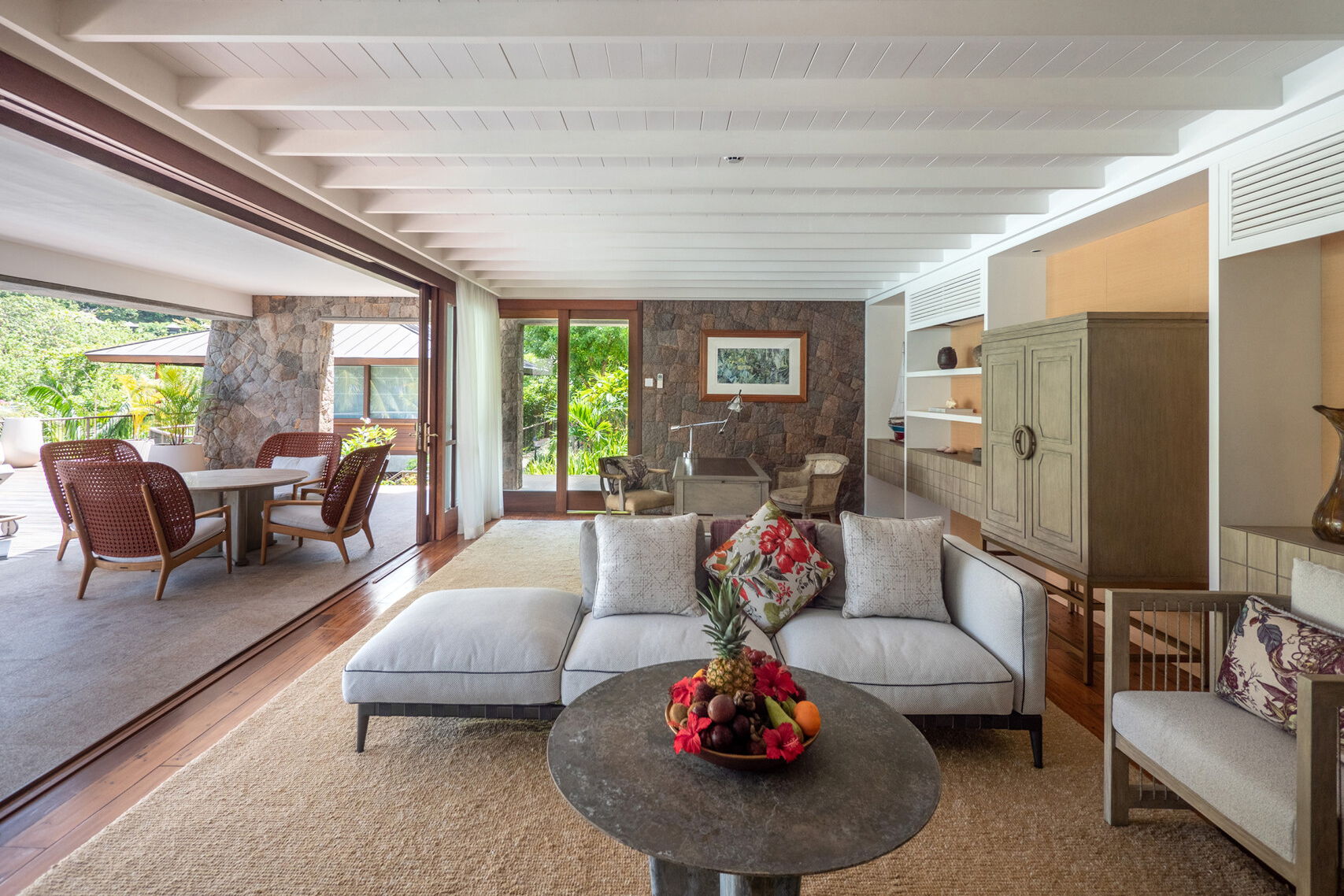 Villa lounge area with plush grey sofas and outdoor terrace seating