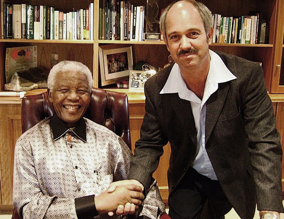 Christo Brand shaking hands with Nelson Mandala who is sat down