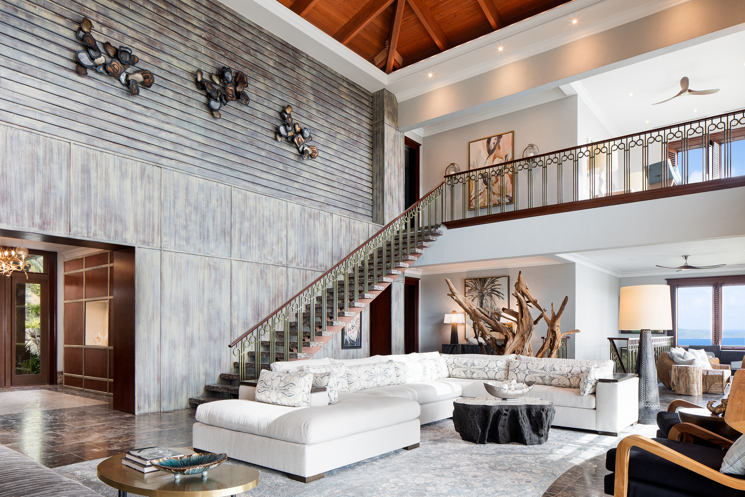 Large two storey villa lounge with staircase, white sofa and artwork 