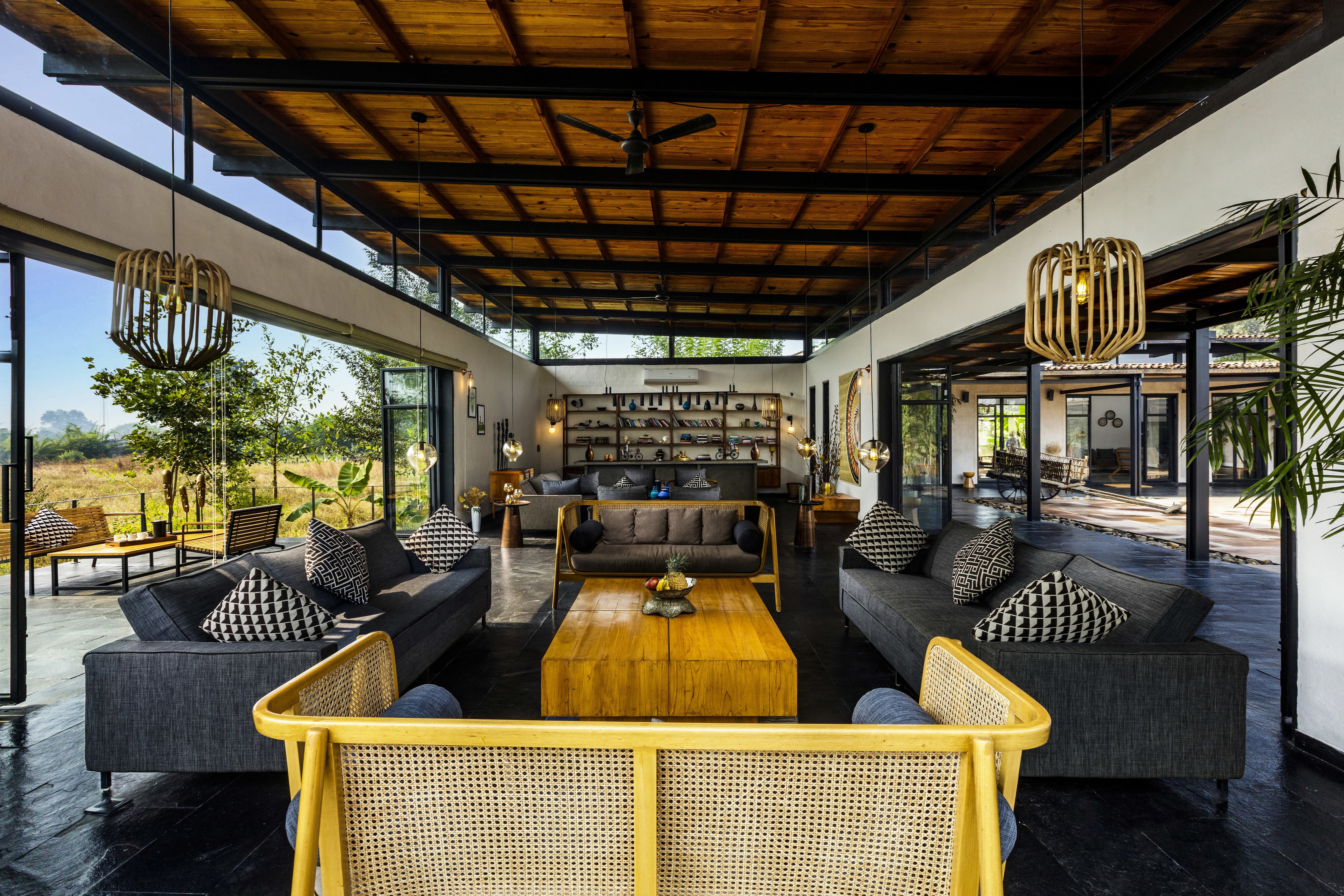 Lounge pavilion with accent yellow sofa standing out against black furniture and beamed ceilings