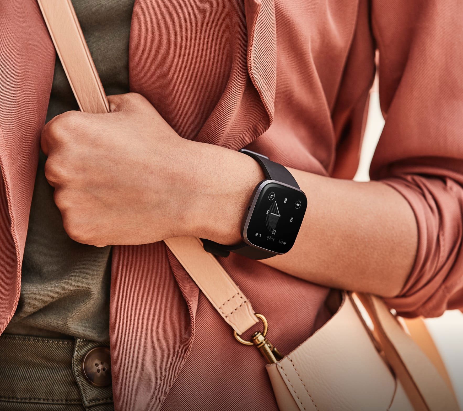 A close up shot of the Fitbit Versa 2 smartwatch in black on a woman's wrist