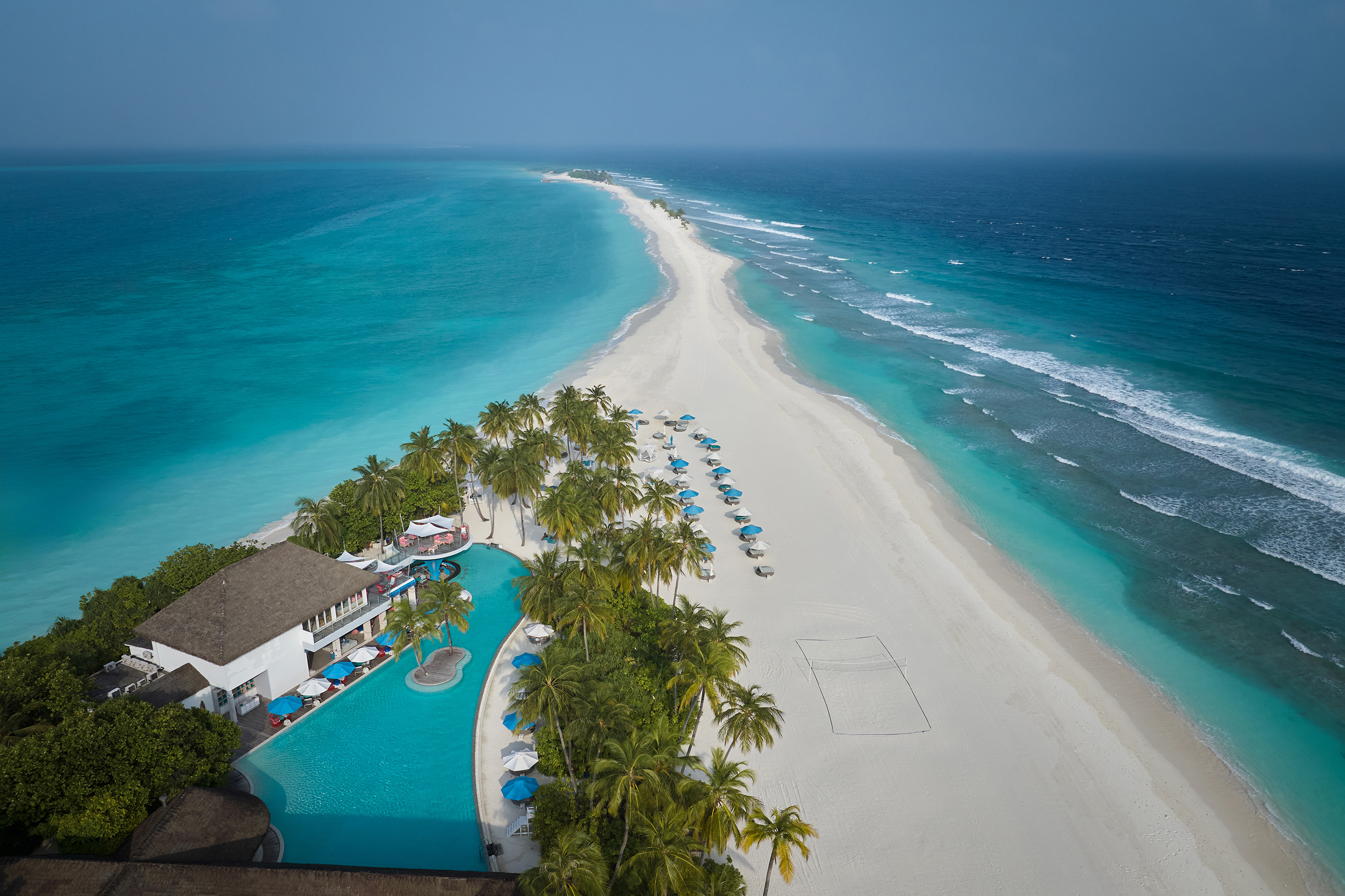 An aerial view of Finolhu's sandbank and swimming pool under a clear sky