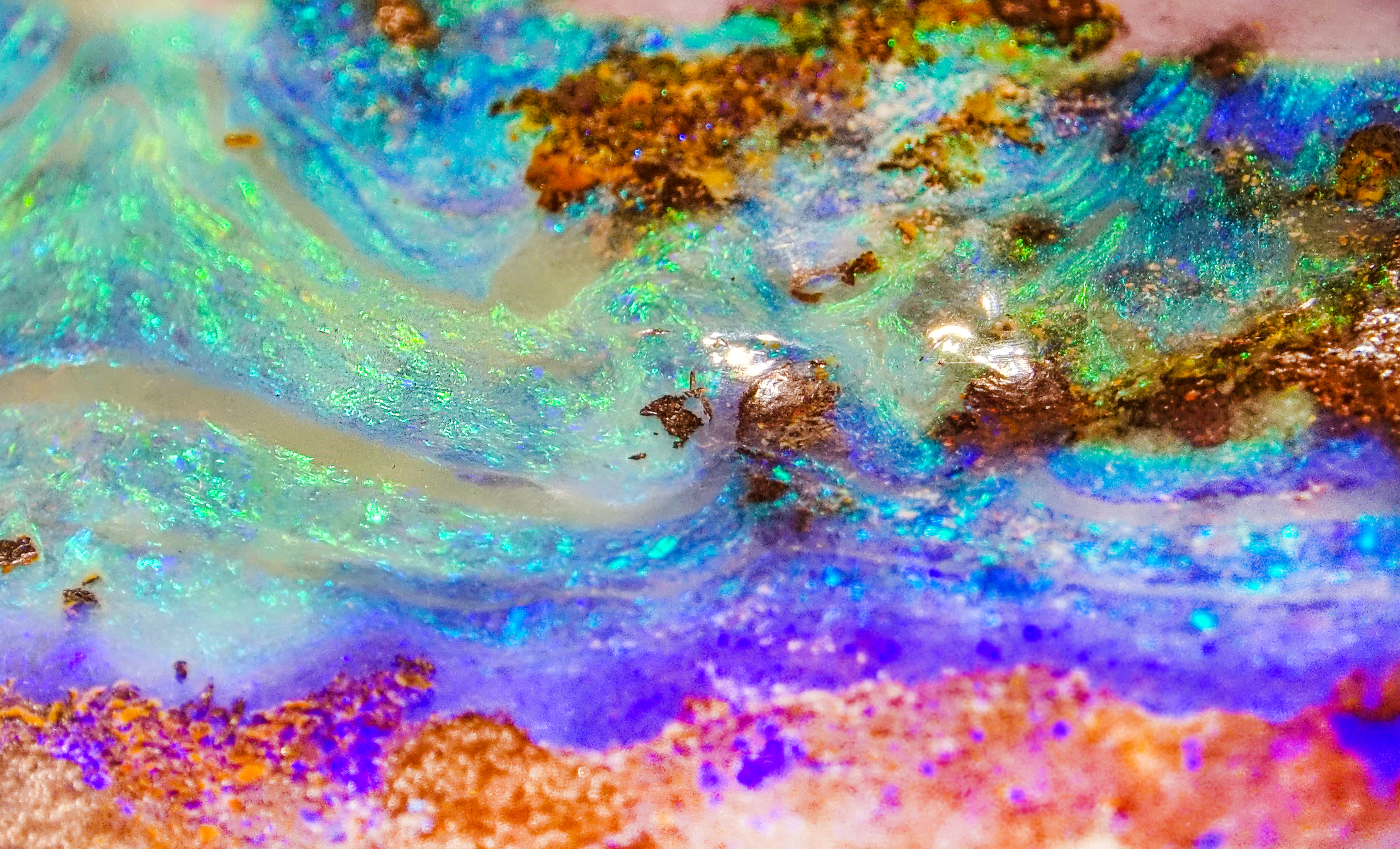 An extreme close up on a a multi coloured opal