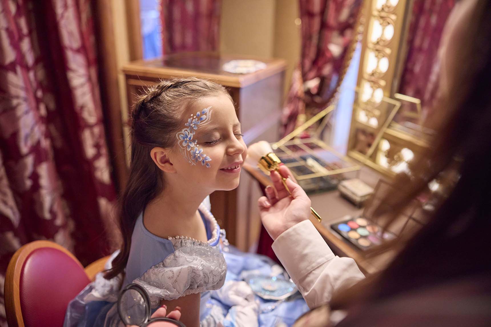 Europe, France, Paris, Disneyland® Hotel, a guest dressed and Cinderella having her makeup done as part of the My Royal Dream experience