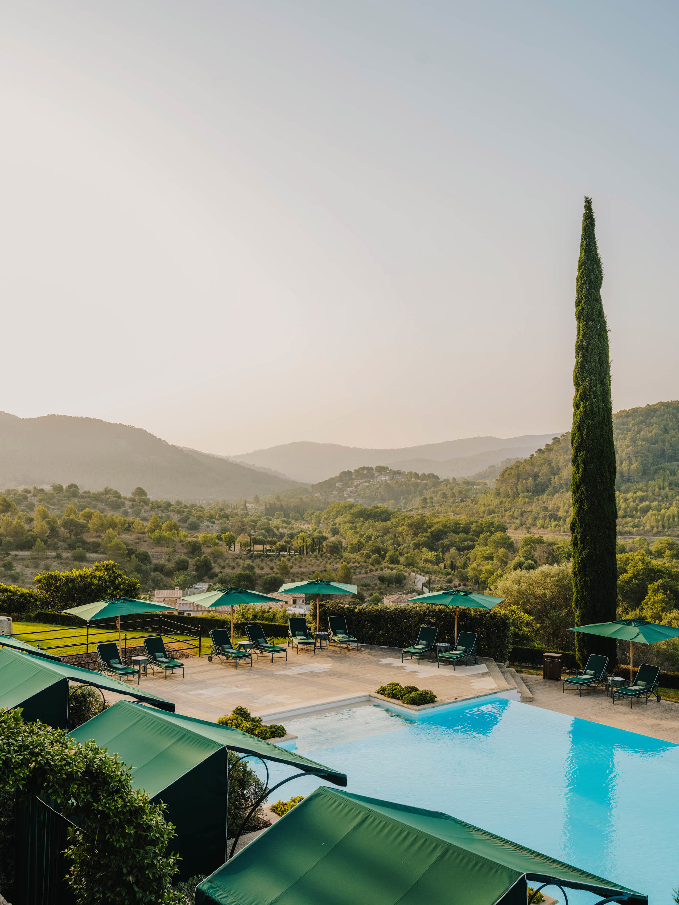 Pool with green loungers and a view of the mountains at Son Net