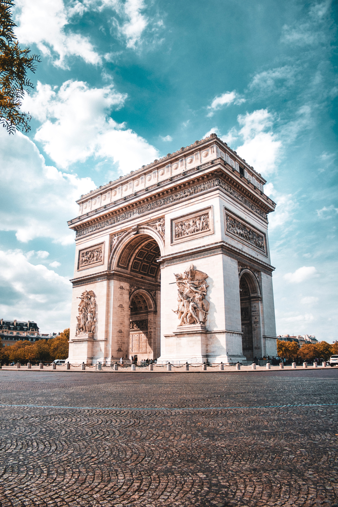 The big white arch of the Arc de Triomphe under a bright sky