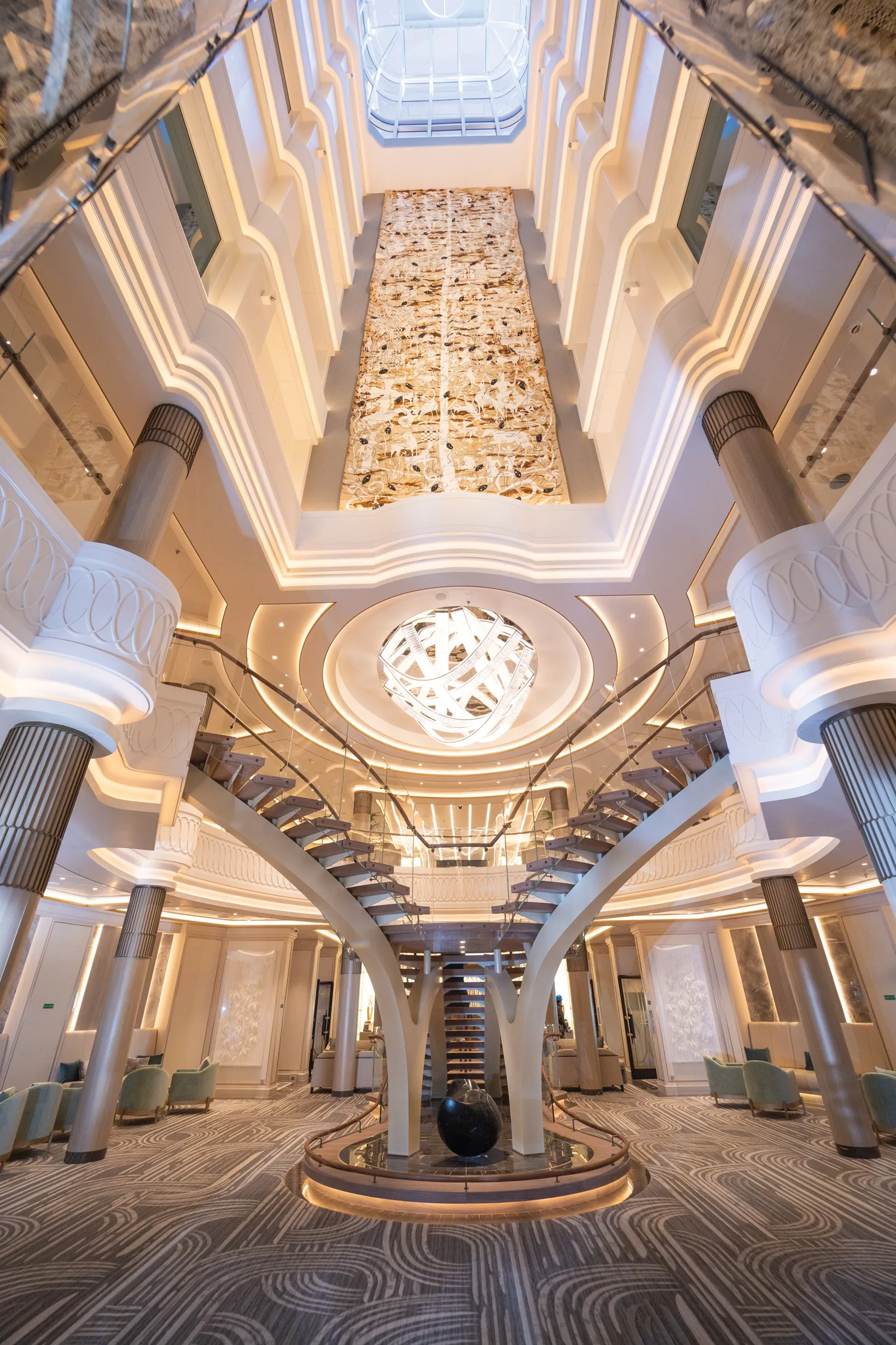 Grand multi-level atrium featuring a central spiral staircase, ornate lighting, and luxurious decor.