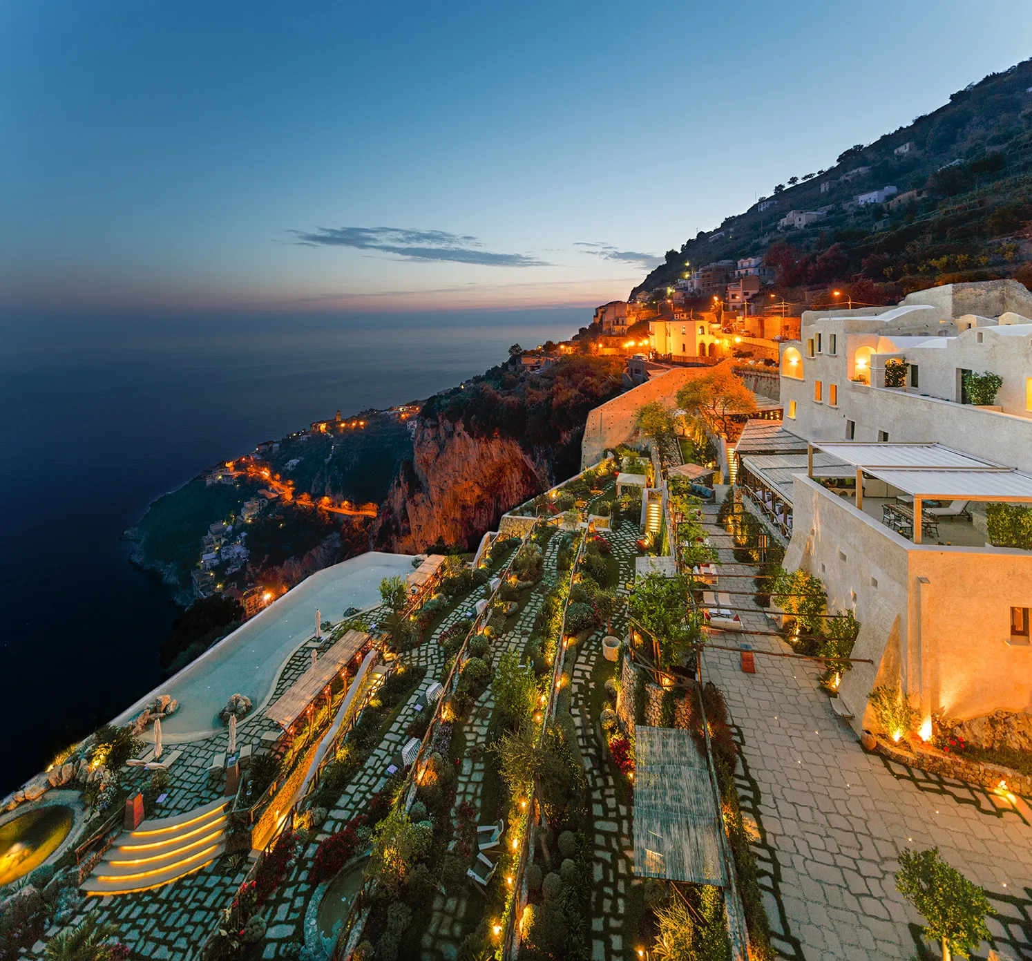 Europe, Italy, Amalfi Coast, Monastero Santa Rosa, outdoor terrace with soft warm lighting at dusk