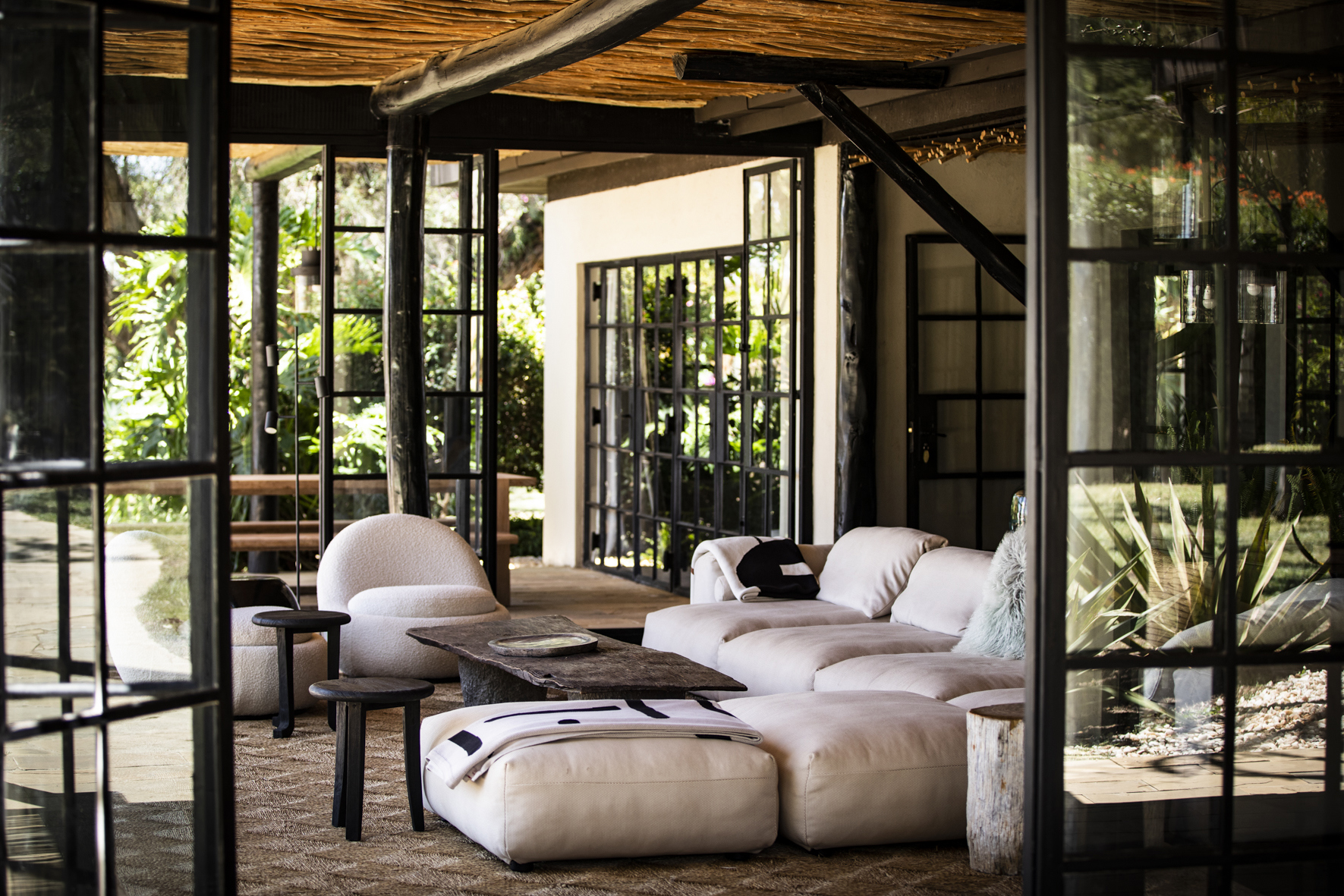 An open lounge area with large windows featuring plush white sofas and a coffee table